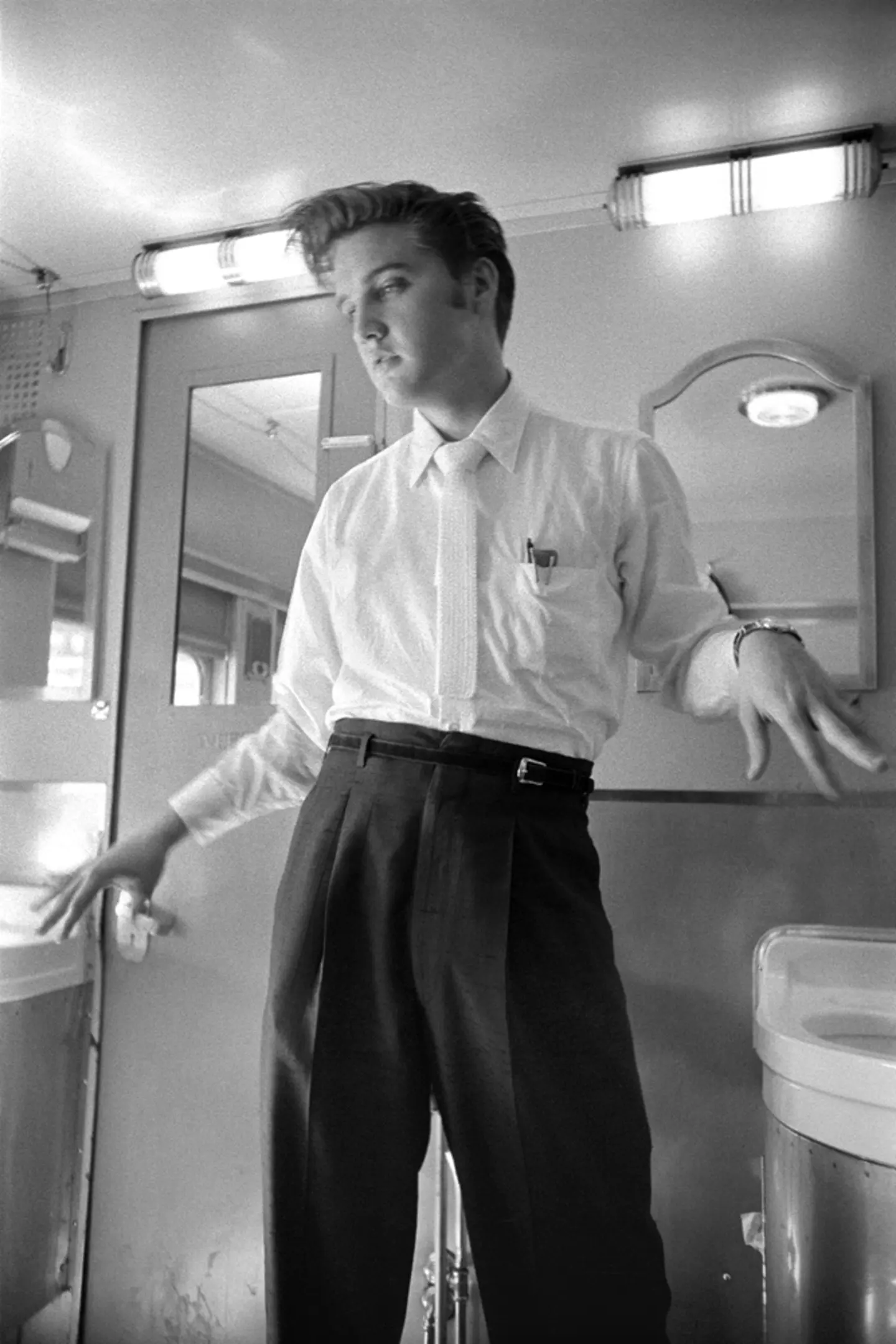 July 4, 1956. On the 27 hour train journey back home to Memphis. No more paper towels. People wanted to know if Elvis was gay… is this really a gay pose? How would you pose if you washed your hands and there are no more paper towels? Elvis is shaking his hands to dry them.