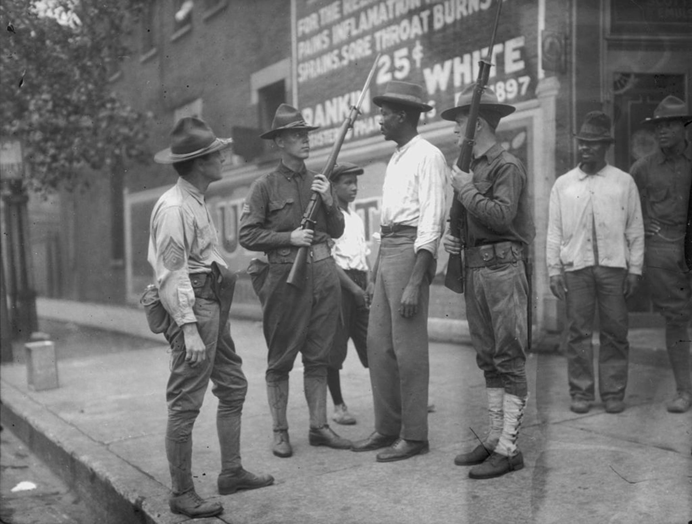 National Guardsmen question an African-American man in Chicago, after Mayor 'Big Bill' Thompson called in the National Guard on July 30, 1919, after three days of rioting.