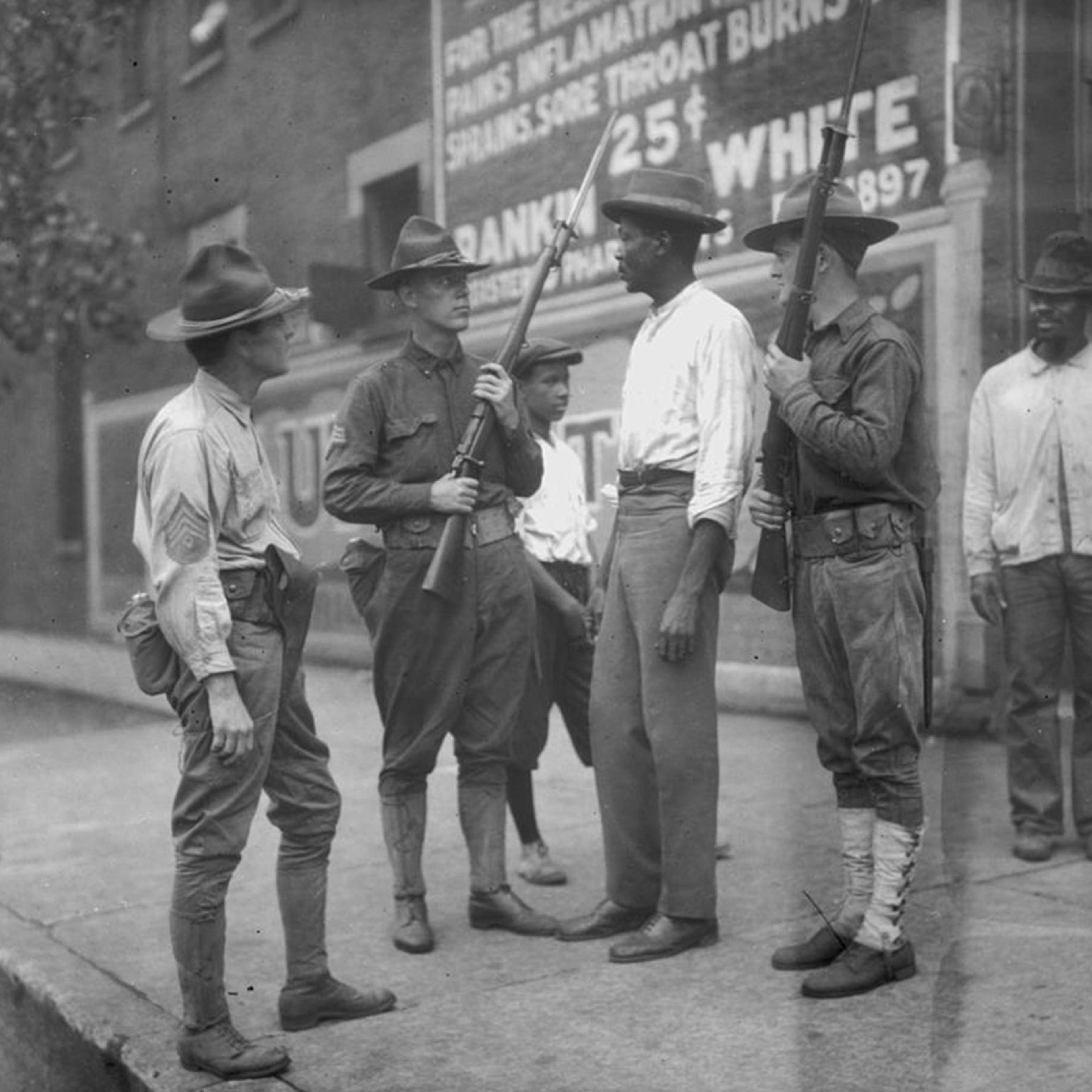 National Guardsmen question an African-American man in Chicago, after Mayor 'Big Bill' Thompson called in the National Guard on July 30, 1919, after three days of rioting.