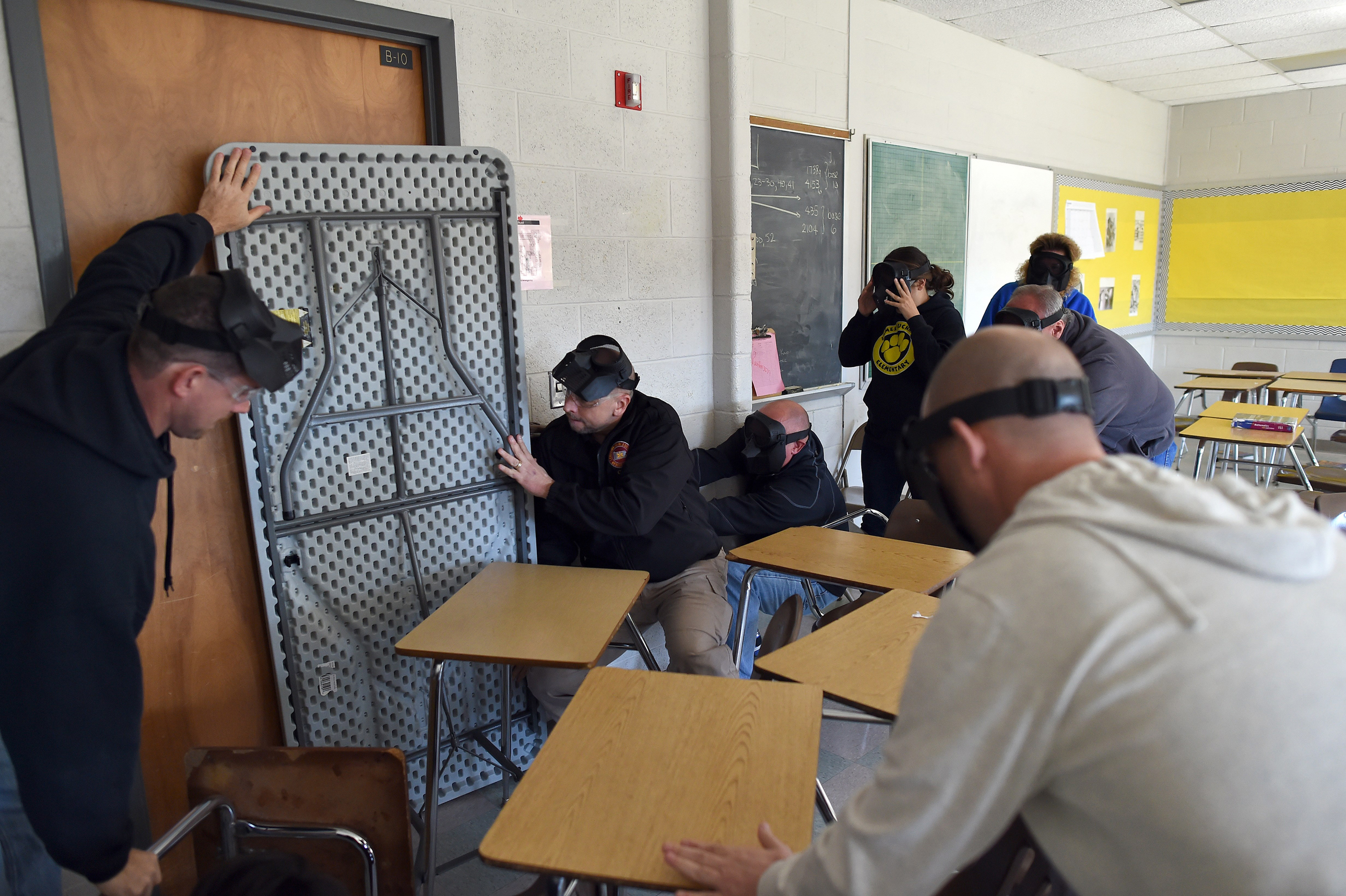 Participants barricade a door of a classroom to block an "active shooter" during ALICE (Alert, Lockdown, Inform, Counter and Evacuate) training at the Harry S. Truman High School in Levittown, Pennsylvania, on November 3, 2015. ALICE is designed to educa