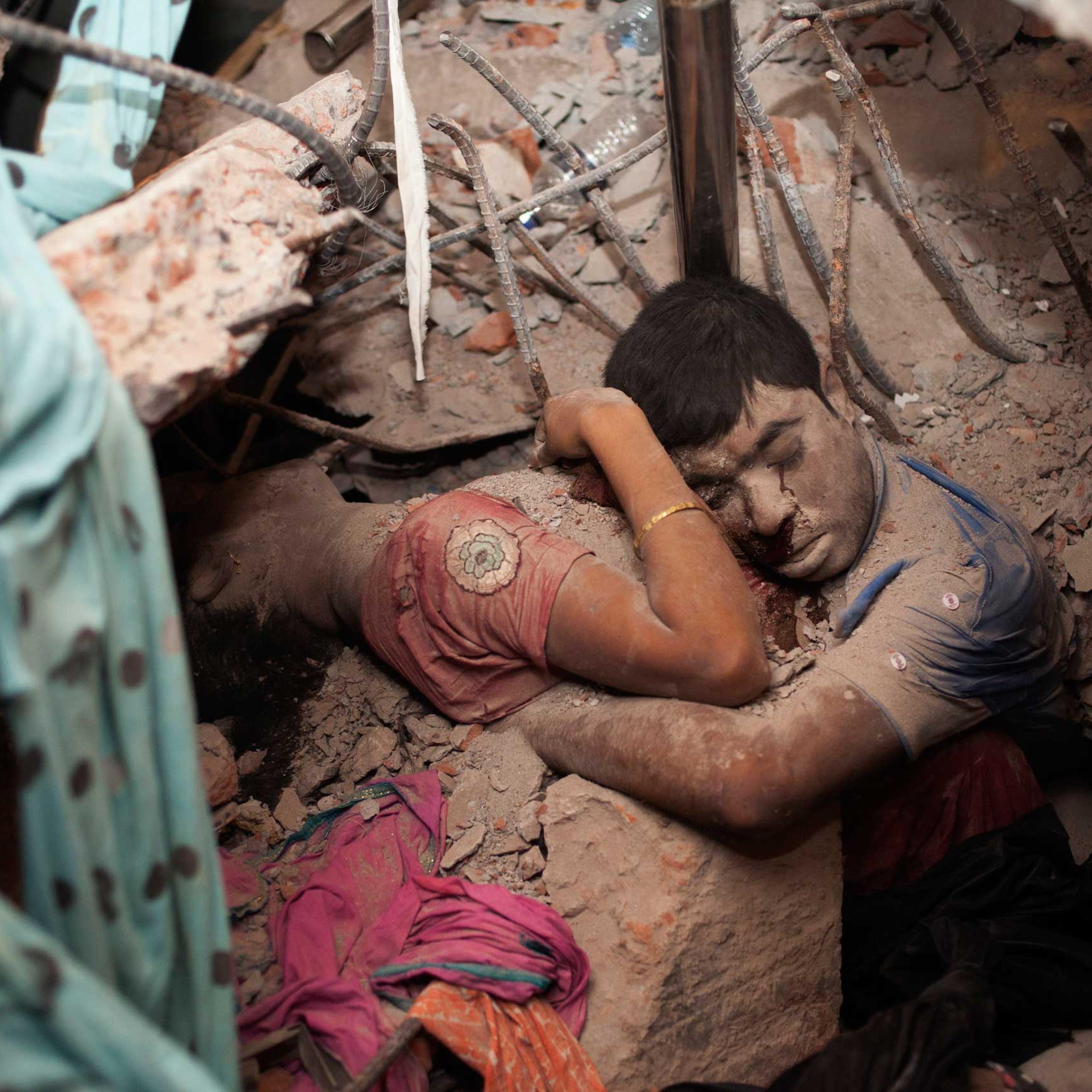 April 25, 2013. Two victims amid the rubble of a garment factory building collapse in Savar, near Dhaka, Bangladesh.
