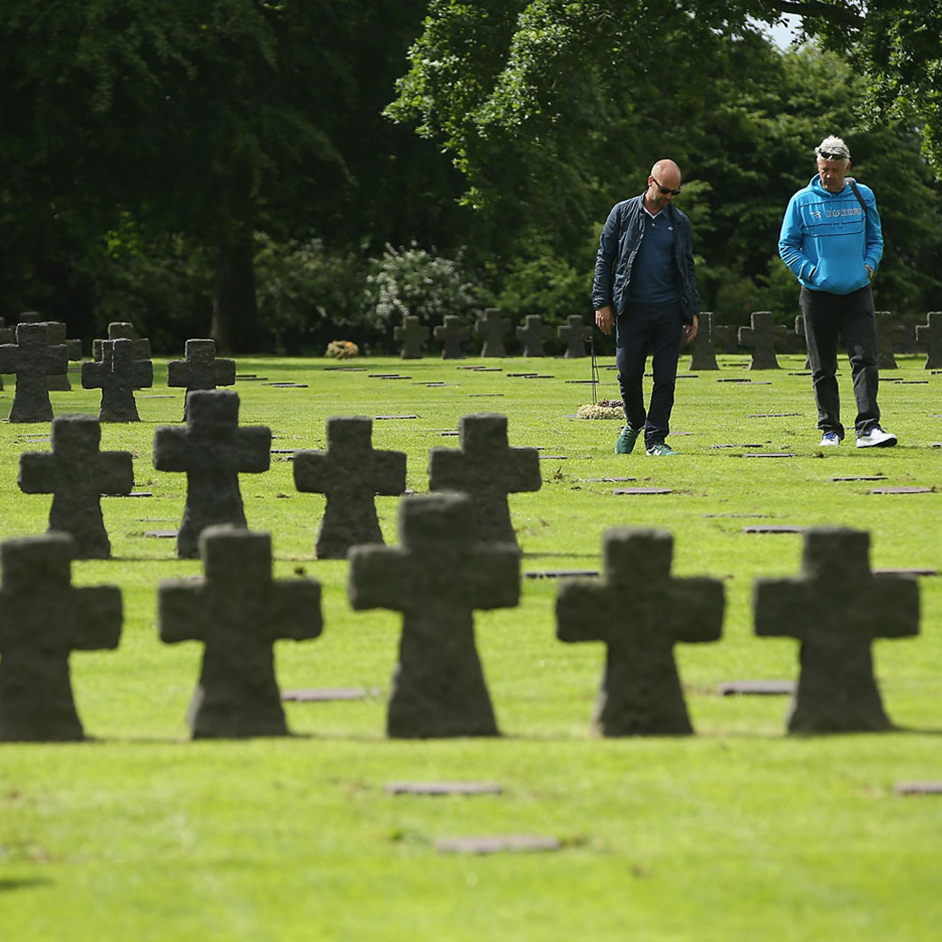 Visitors walk among gravestones at the German Cemetery where approximately 21,000 German World War II soldiers are buried on June 5, 2014 at La Cambe, France.