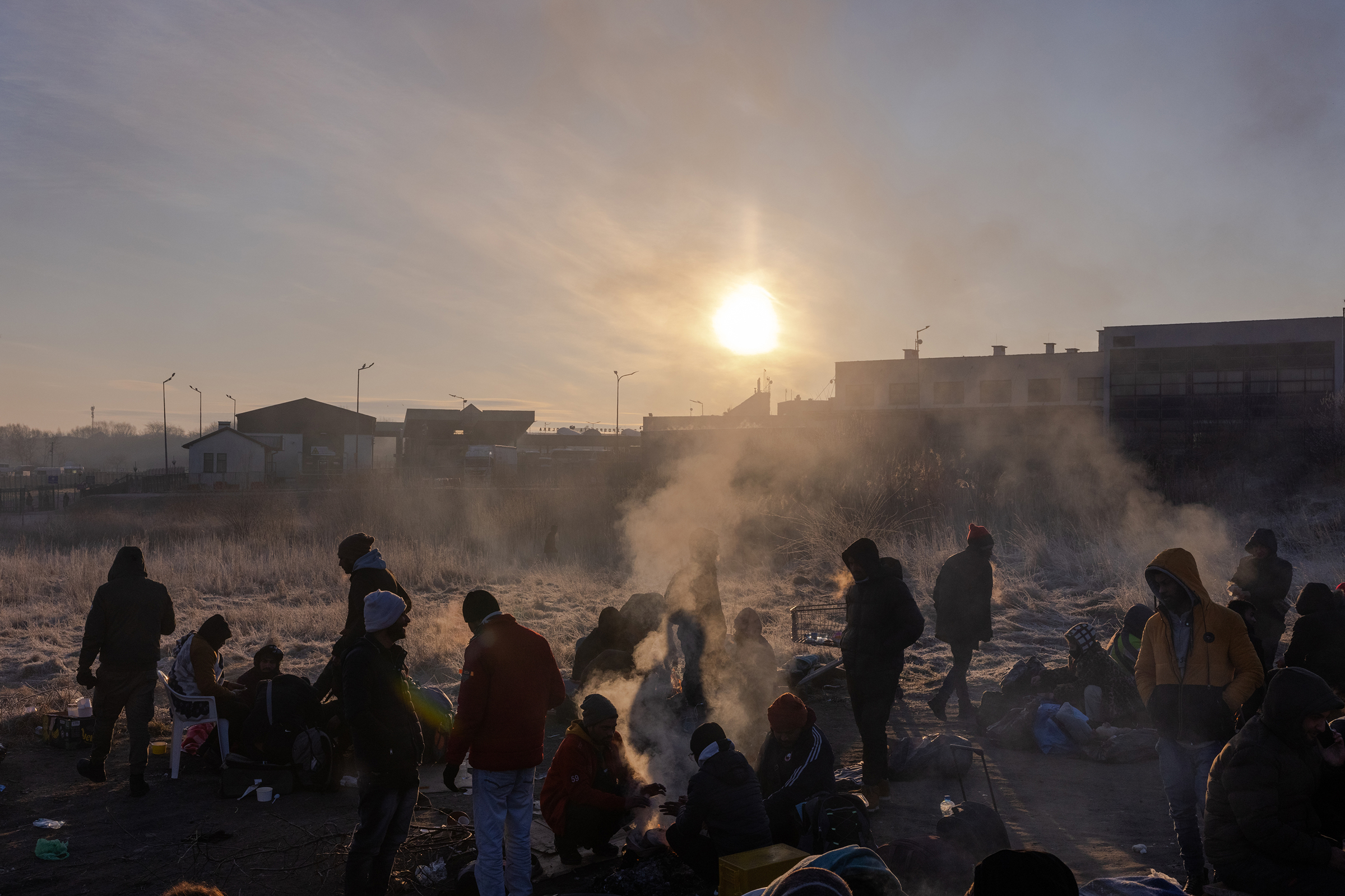 Refugees wake after sleeping on blankets and cardboard on the ground on the Polish side of the Medyka crossing, on March 1.