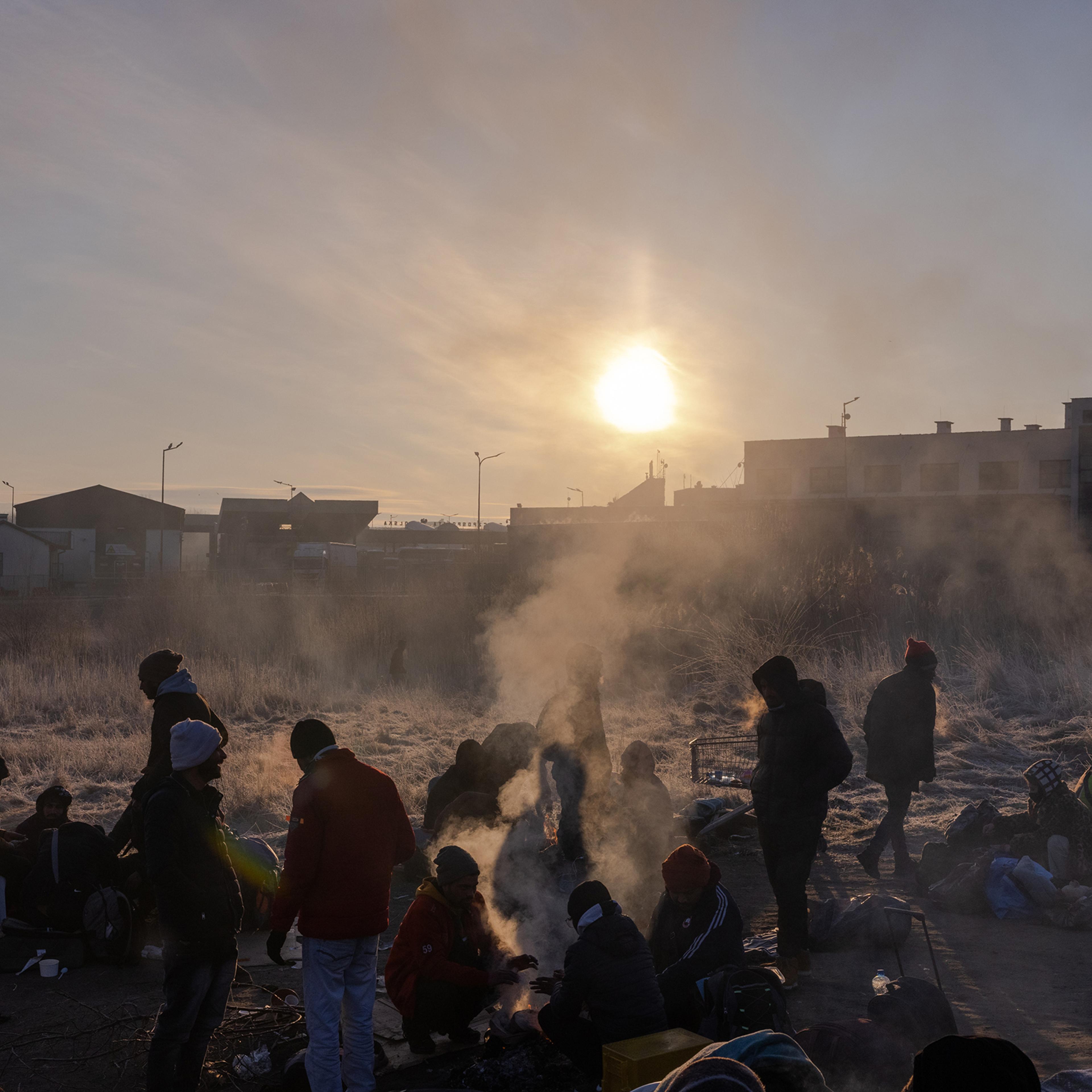 Refugees wake after sleeping on blankets and cardboard on the ground on the Polish side of the Medyka crossing, on March 1.