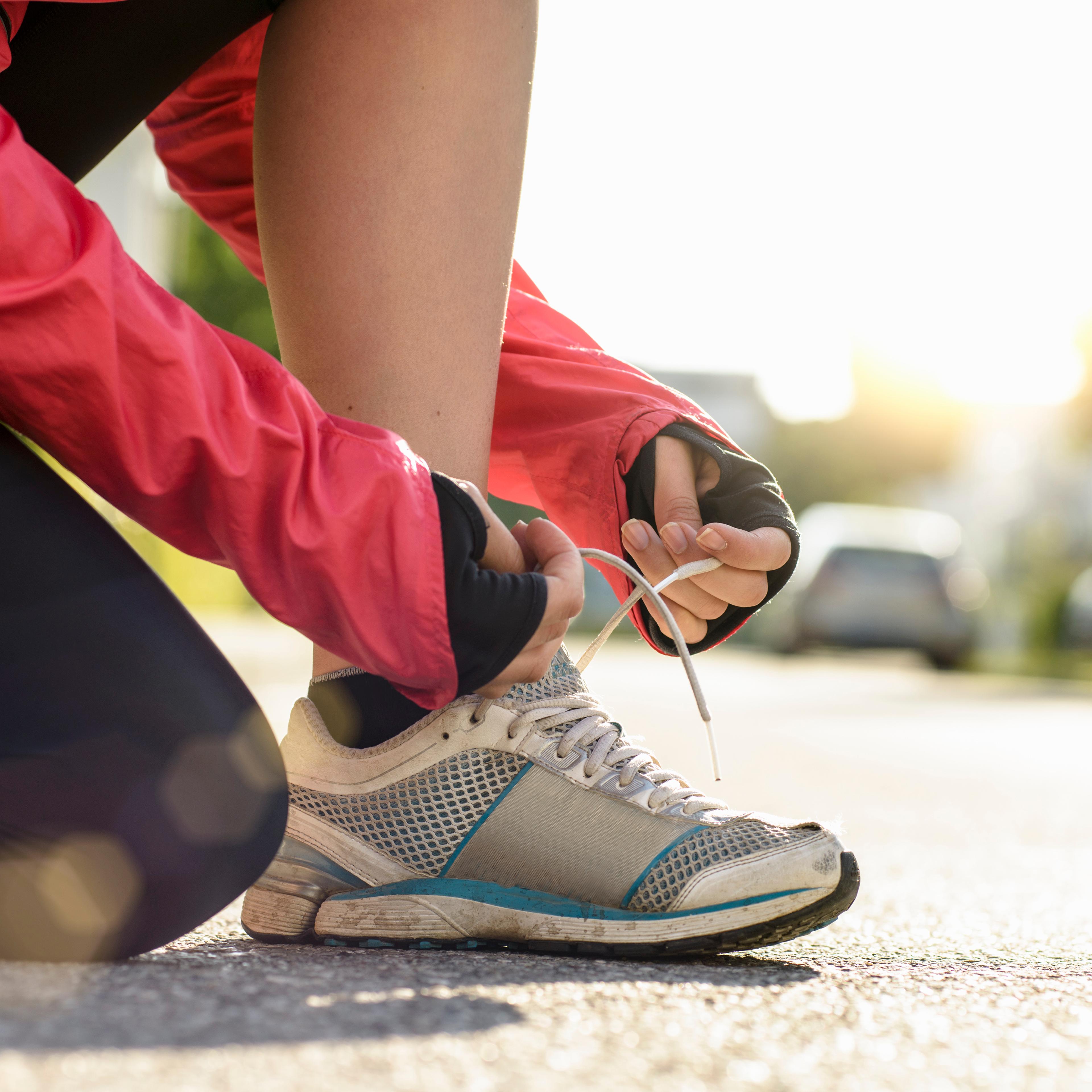 female runner tying shoe lace in a urban area