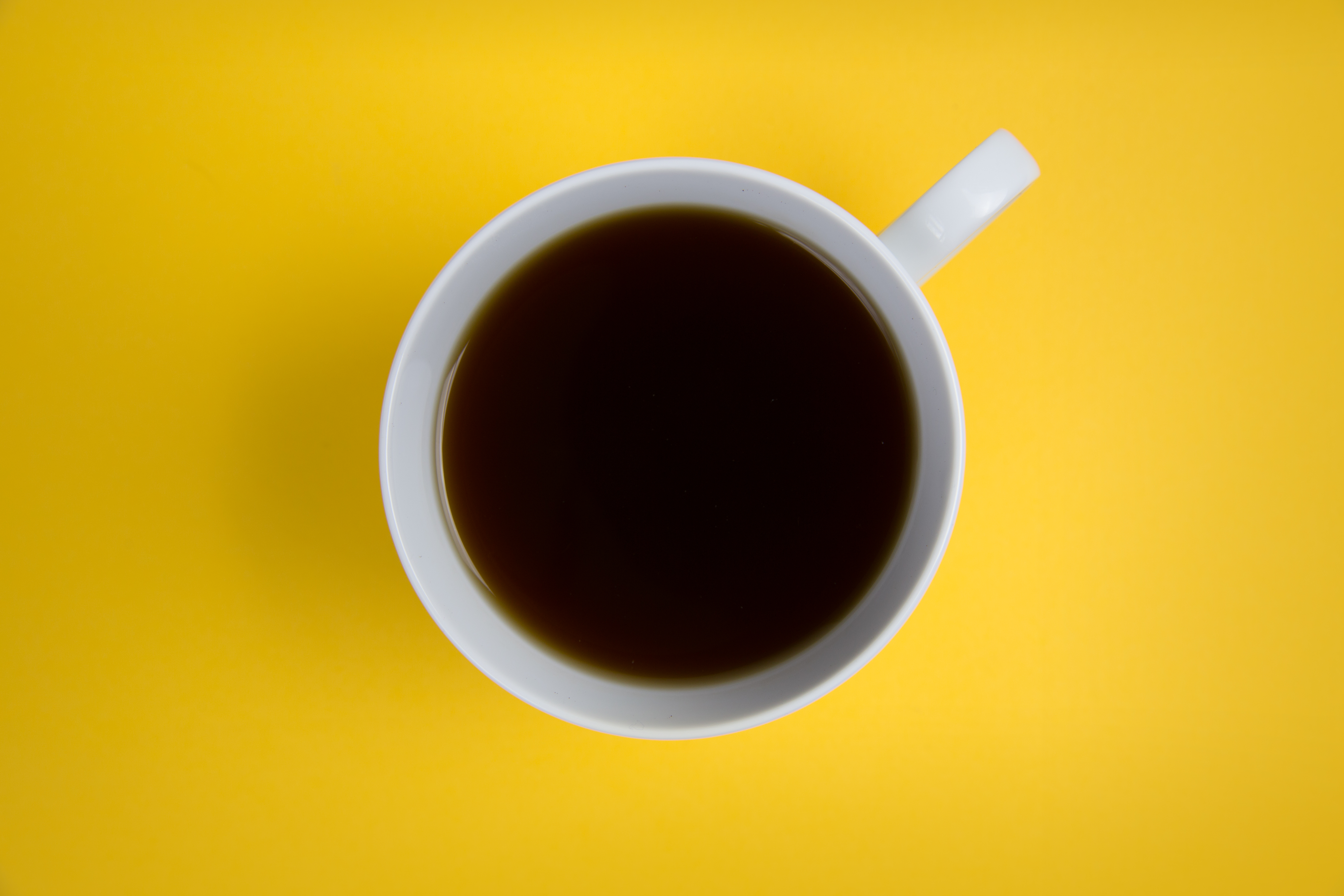 Directly Above Shot Of Coffee On Yellow Background