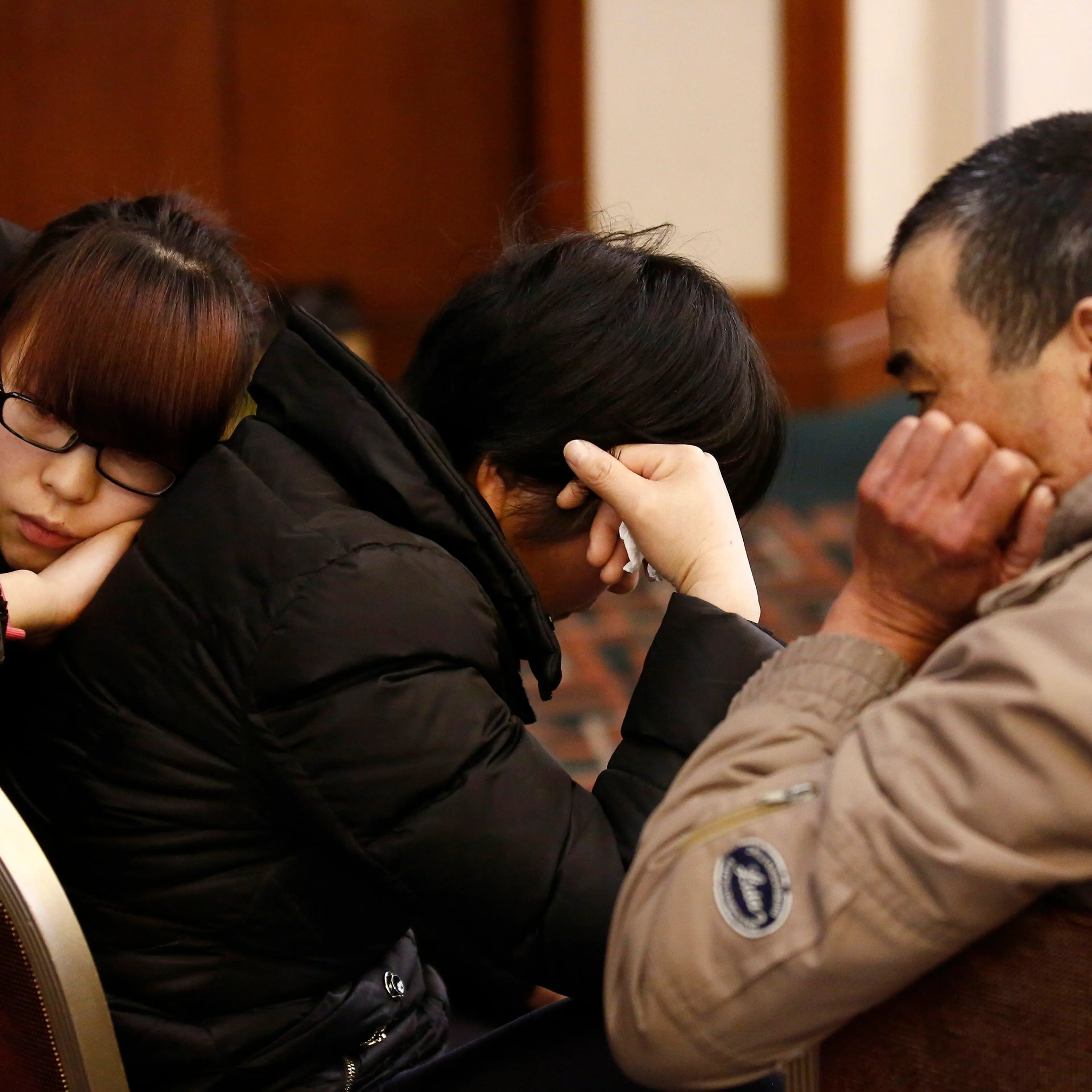 Family members of a passenger onboard the missing Malaysia Airlines flight MH370 react as they listen to a briefing from the airline company at a hotel in Beijing