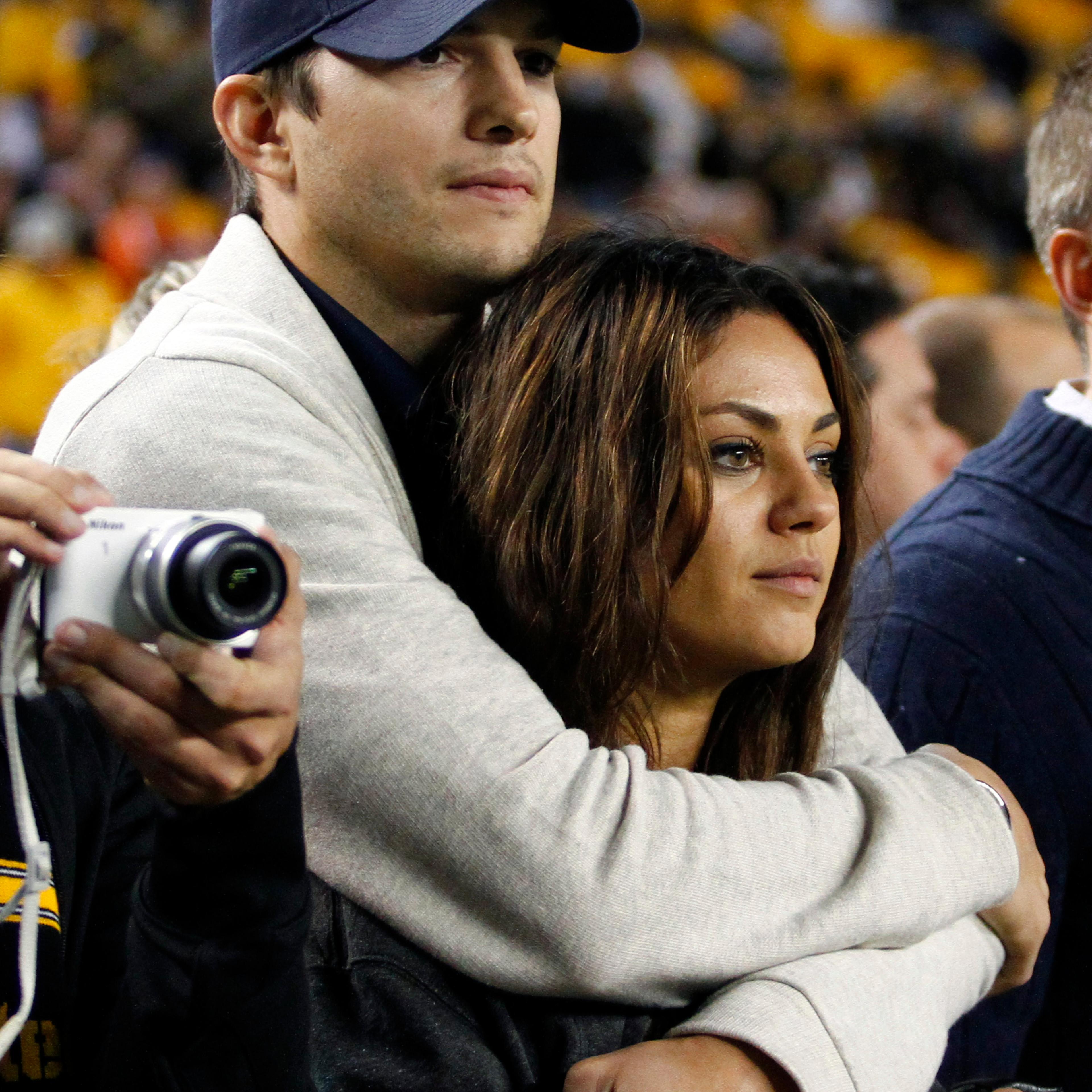 Ashton Kutcher and Mila Kunis look on from the sidelines before the game between the Chicago Bears and the Pittsburgh Steelers on Sept. 22, 2013 at Heinz Field in Pittsburgh.