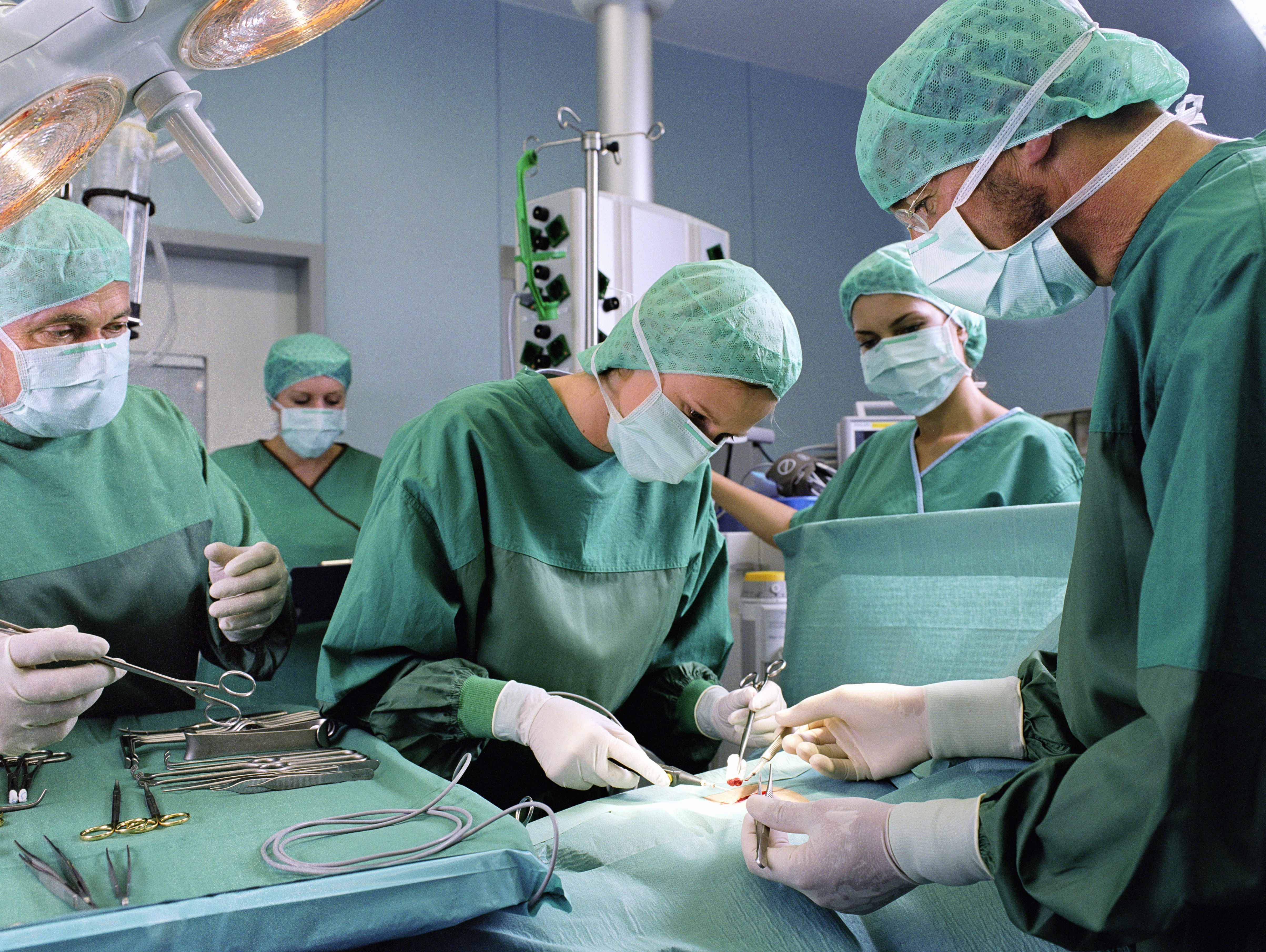 A group of surgeons work in an operating theatre.
