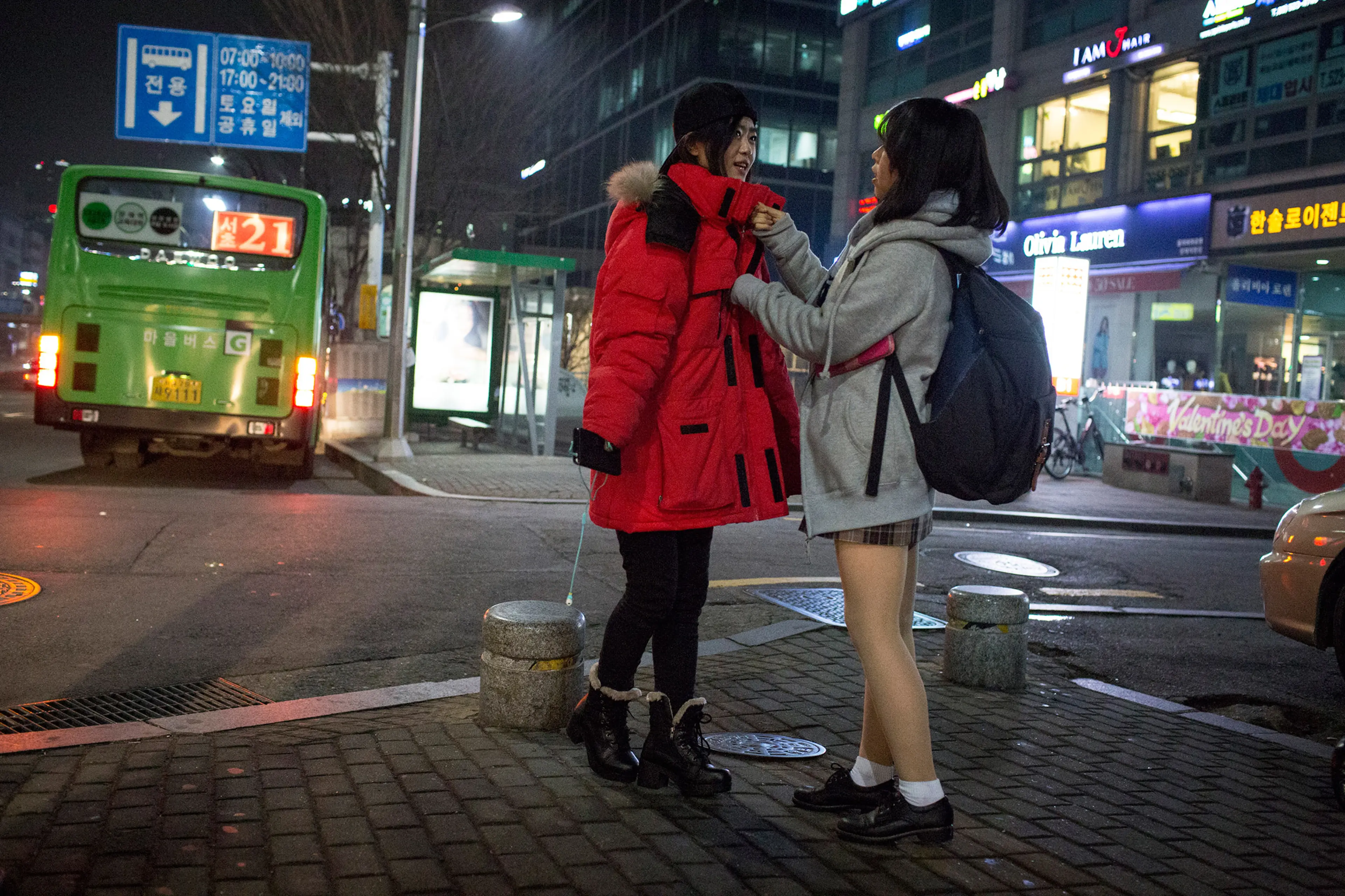 Kyong-ok zips up Sarah's jacket, which she borrowed from her brother, during a night out Feb. 4, 2015 in Seoul, South Korea. The community of North Korean refugees is growing smaller and more tight knit with the help of social networks and human rights g