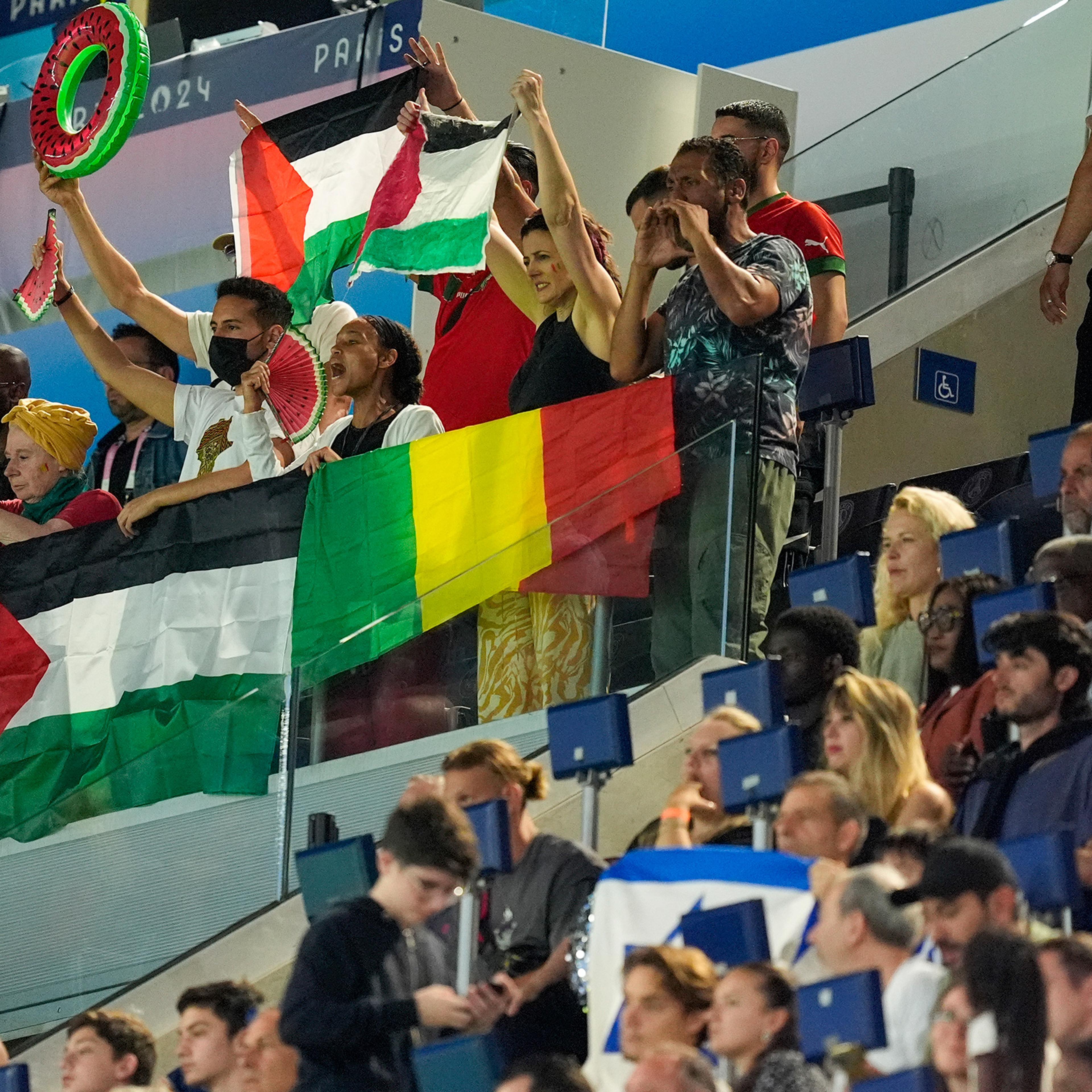 Spectators hold Palestinian flags as they watch the men's group D match between Israel and Mali at the Parc des Princes during the 2024 Summer Olympics on July 24 in Paris.