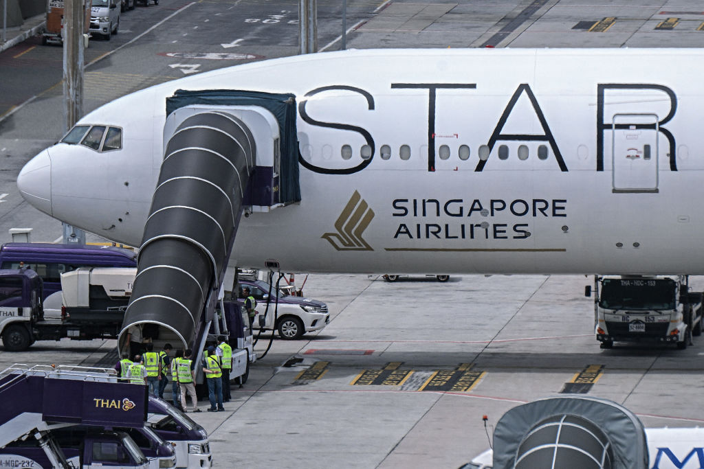 Officials enter the Singapore Airlines Boeing 777-300ER airplane, which was headed to Singapore from London before making an emergency landing in Bangkok due to severe turbulence, as it is parked on the tarmac at Suvarnabhumi International Airport in Ban