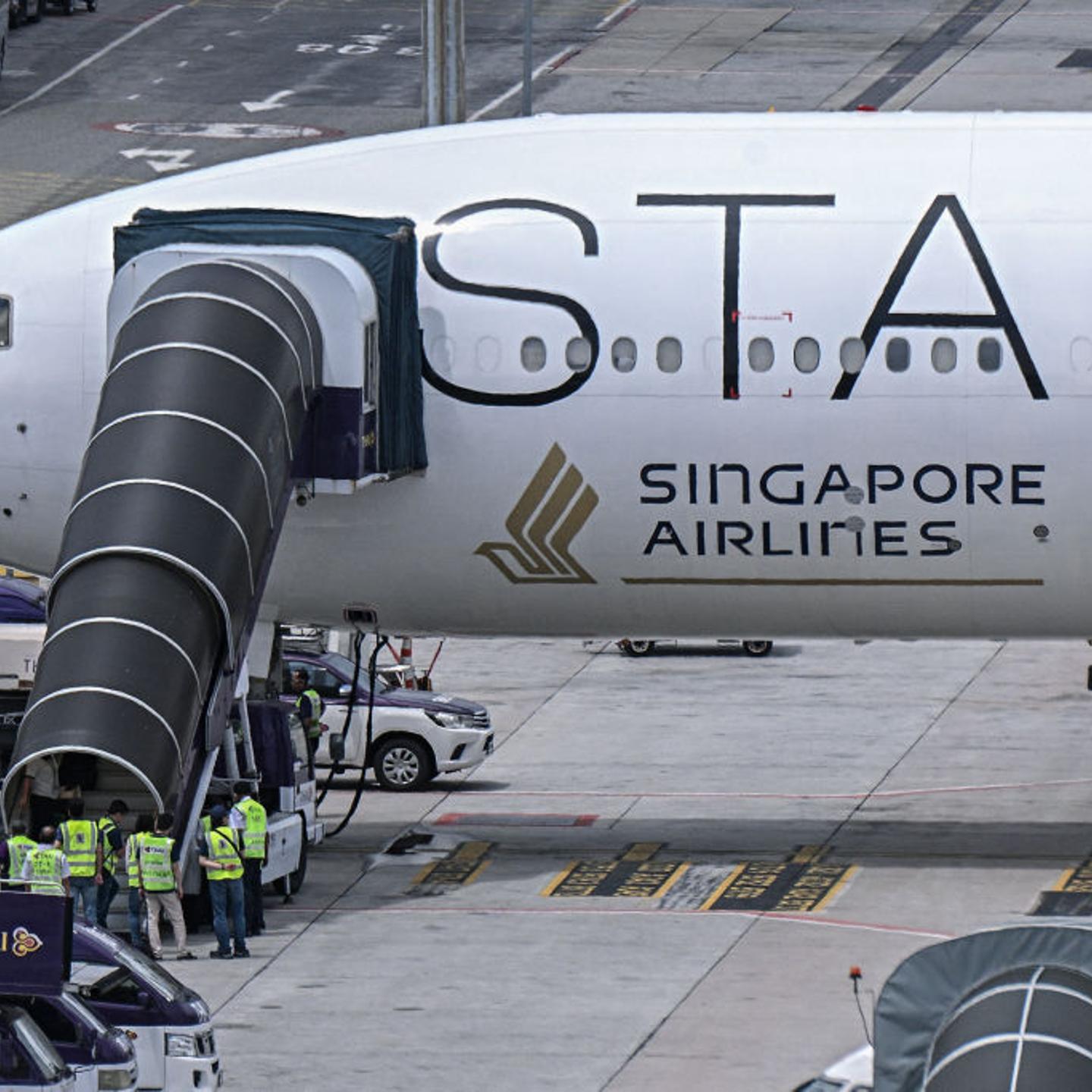 Officials enter the Singapore Airlines Boeing 777-300ER airplane, which was headed to Singapore from London before making an emergency landing in Bangkok due to severe turbulence, as it is parked on the tarmac at Suvarnabhumi International Airport in Ban
