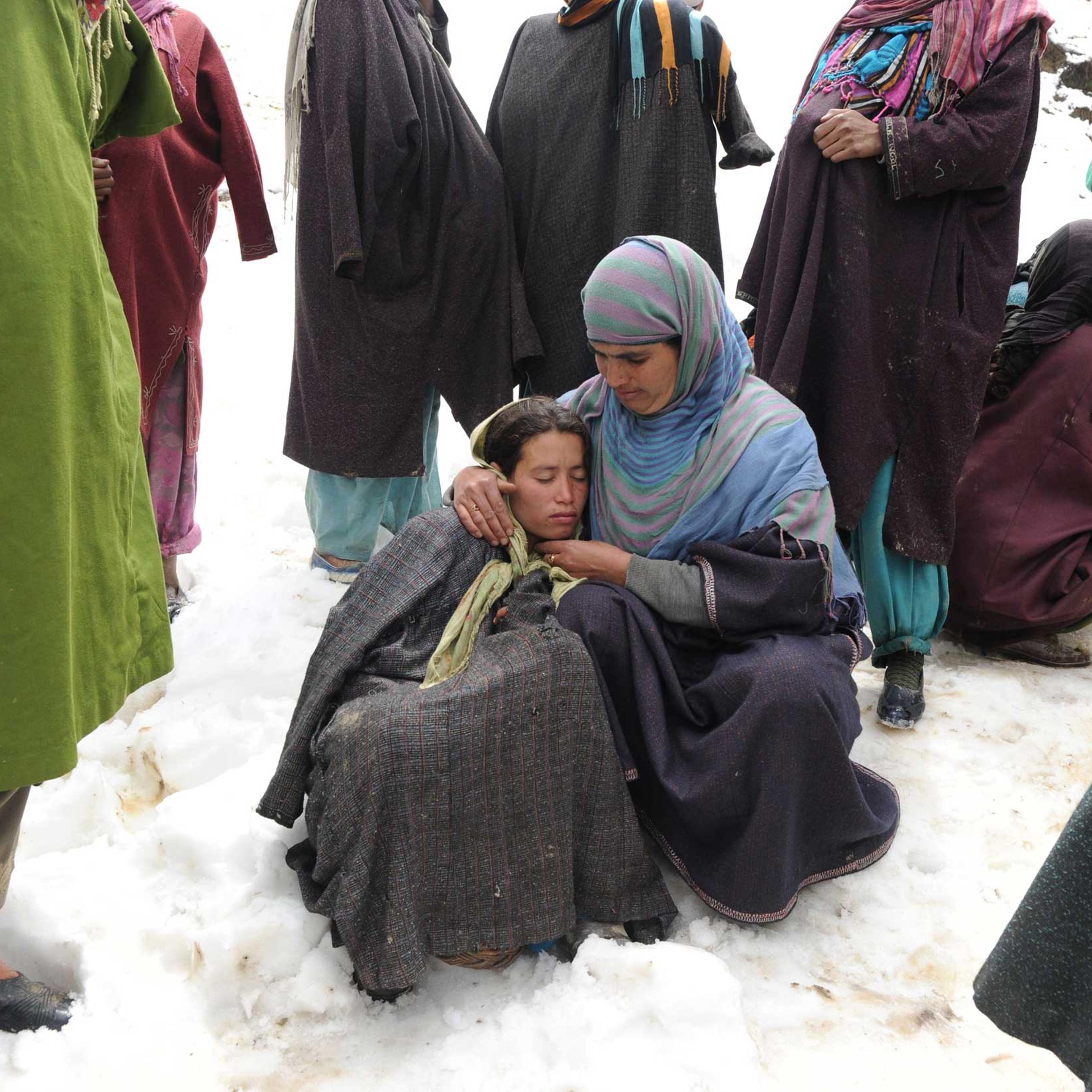 Kashmiri villagers gather during rescue efforts following a landslide due to heavy rainfall in the village of Laden near Chadoora, west of Srinagar, on March 30, 2015.