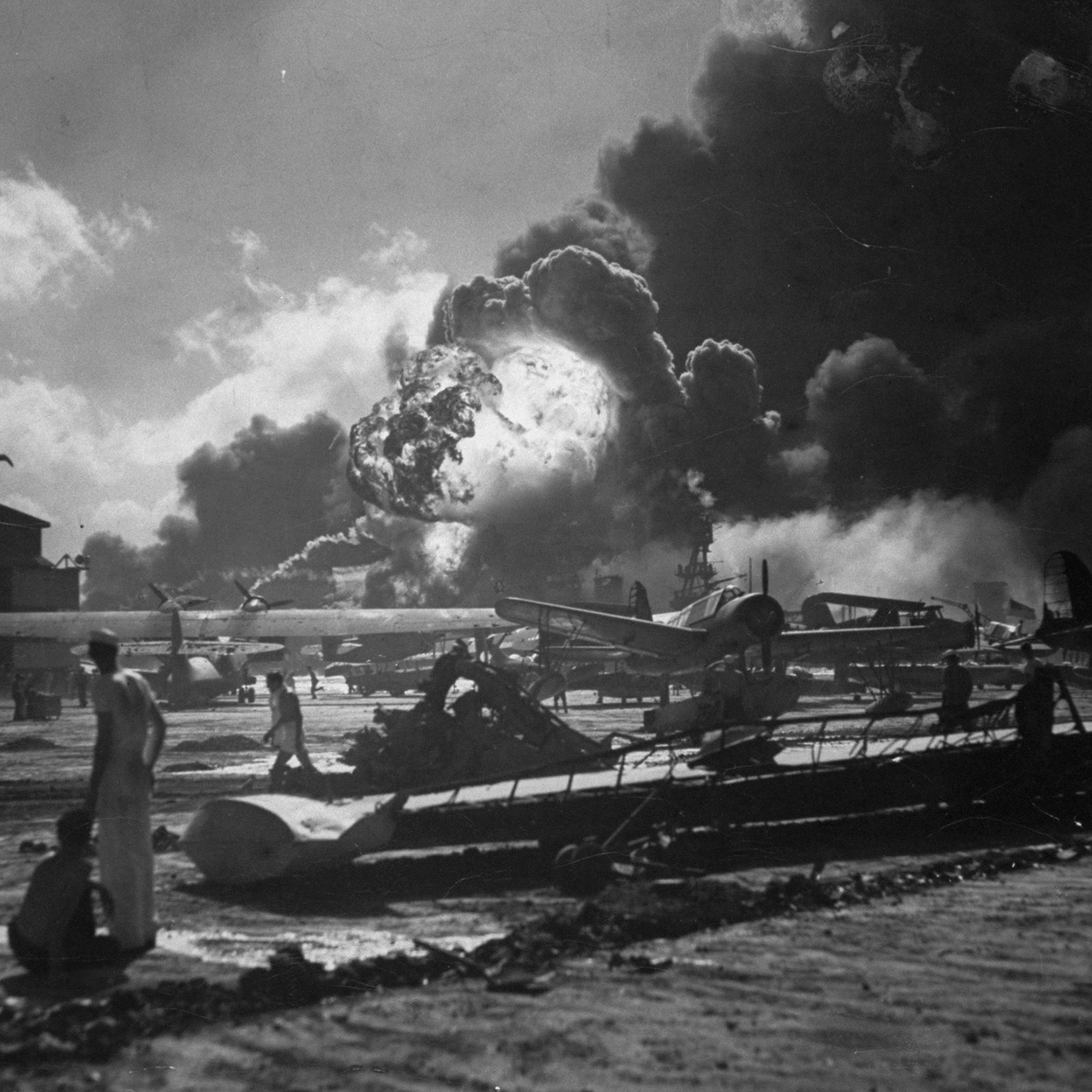 Sailors, planes and a huge ball of fire and smoke at wreckage-strewn Naval Air Station, Hawaii, following one of the Japanese attacks on Pearl Harbor on Dec. 7, 1941.