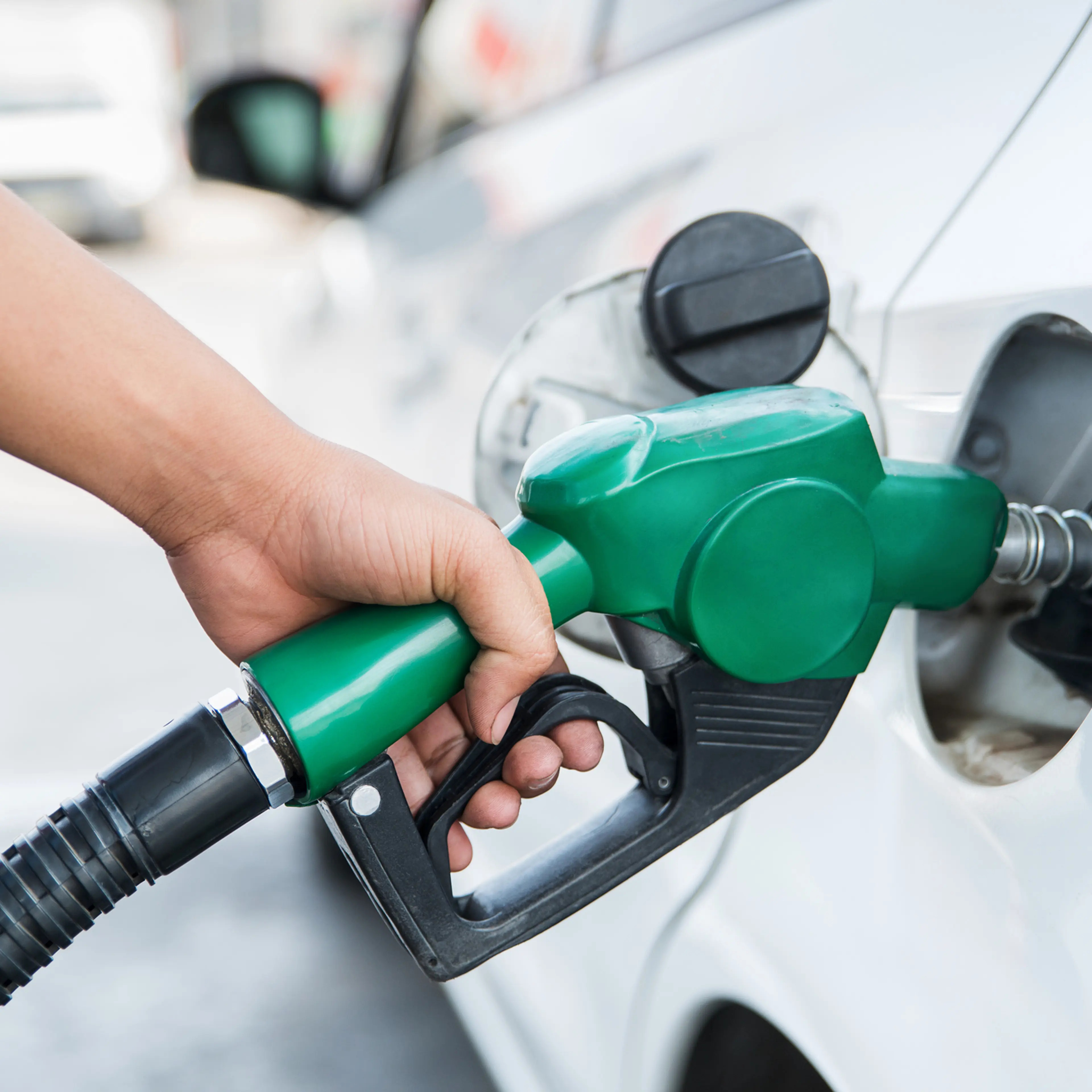 Handle fuel nozzle to refuel the car.