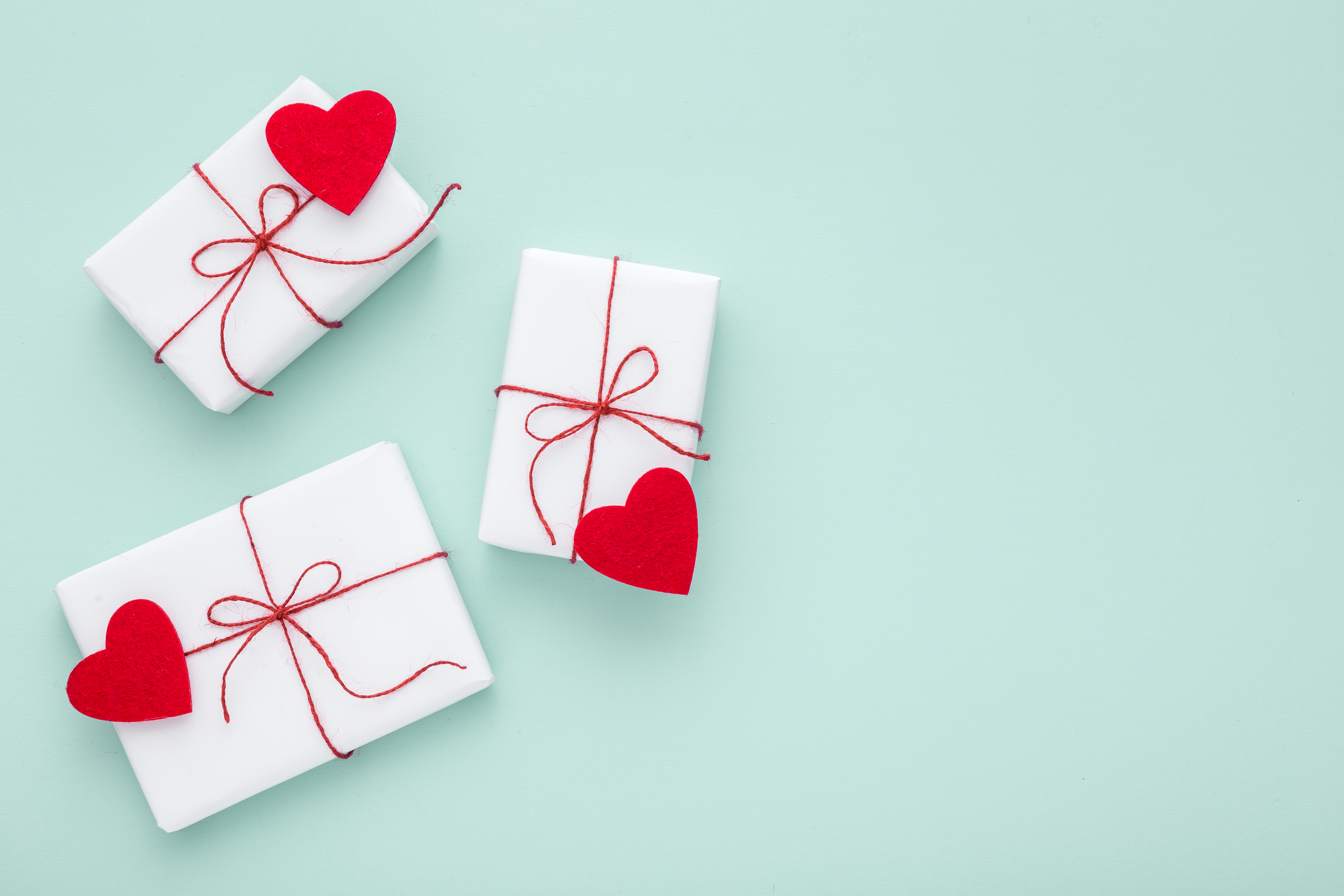 Valentine day composition: white gift boxes, felt hearts, copy space.
