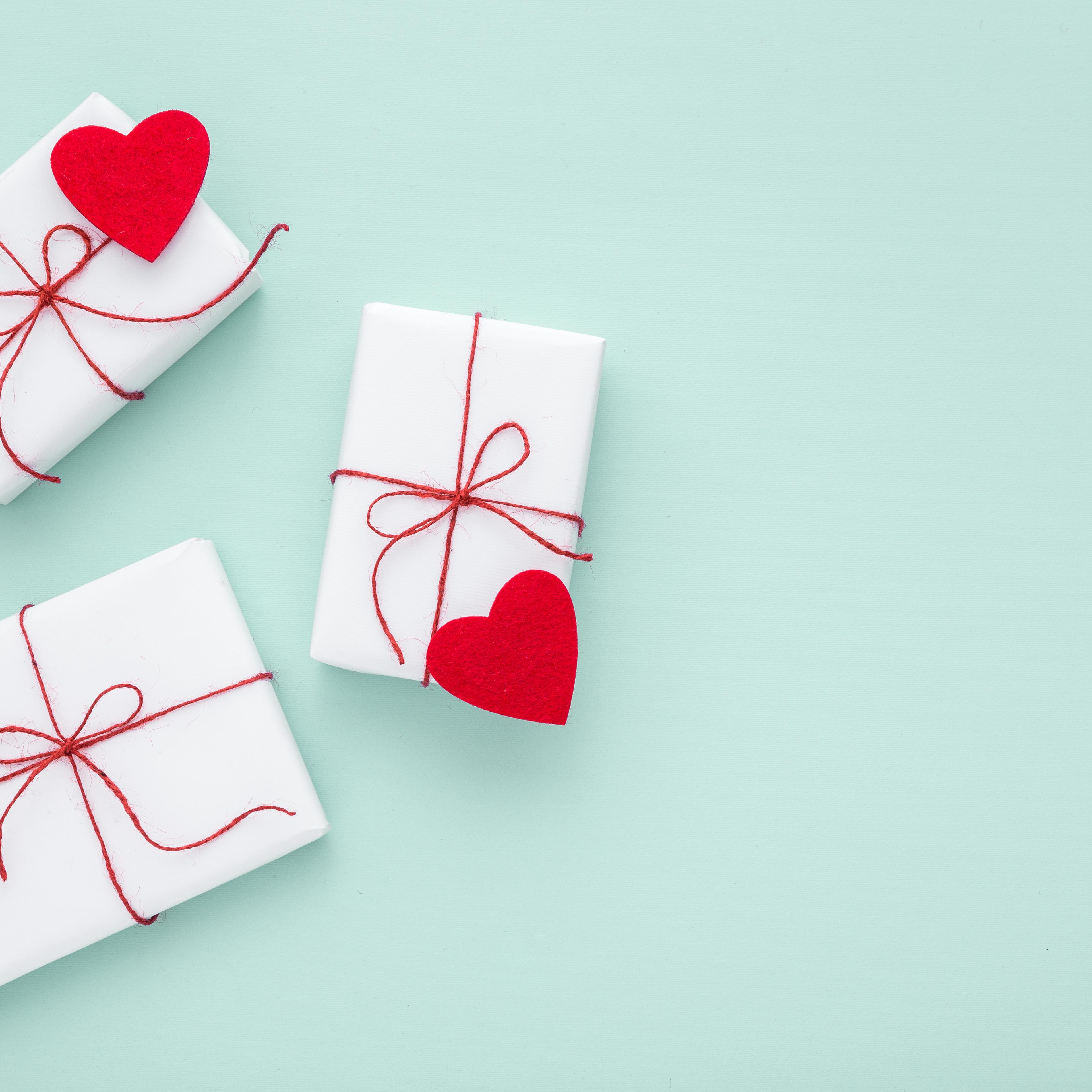 Valentine day composition: white gift boxes, felt hearts, copy space.