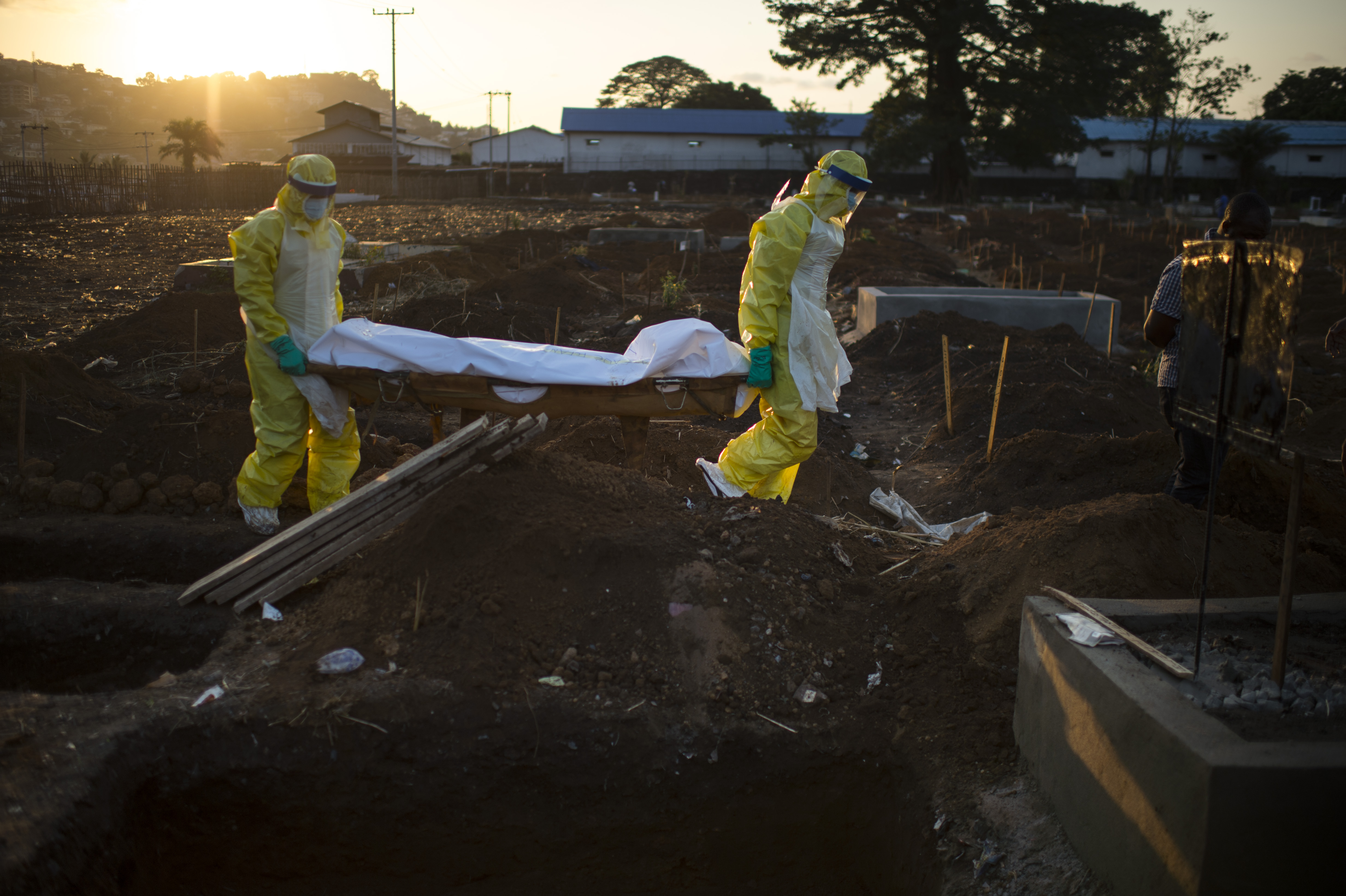 Members of the burial team carry a body to his grave at King Tom Cemetery in Freetown, Sierra Leone, on Nov. 19, 2014.