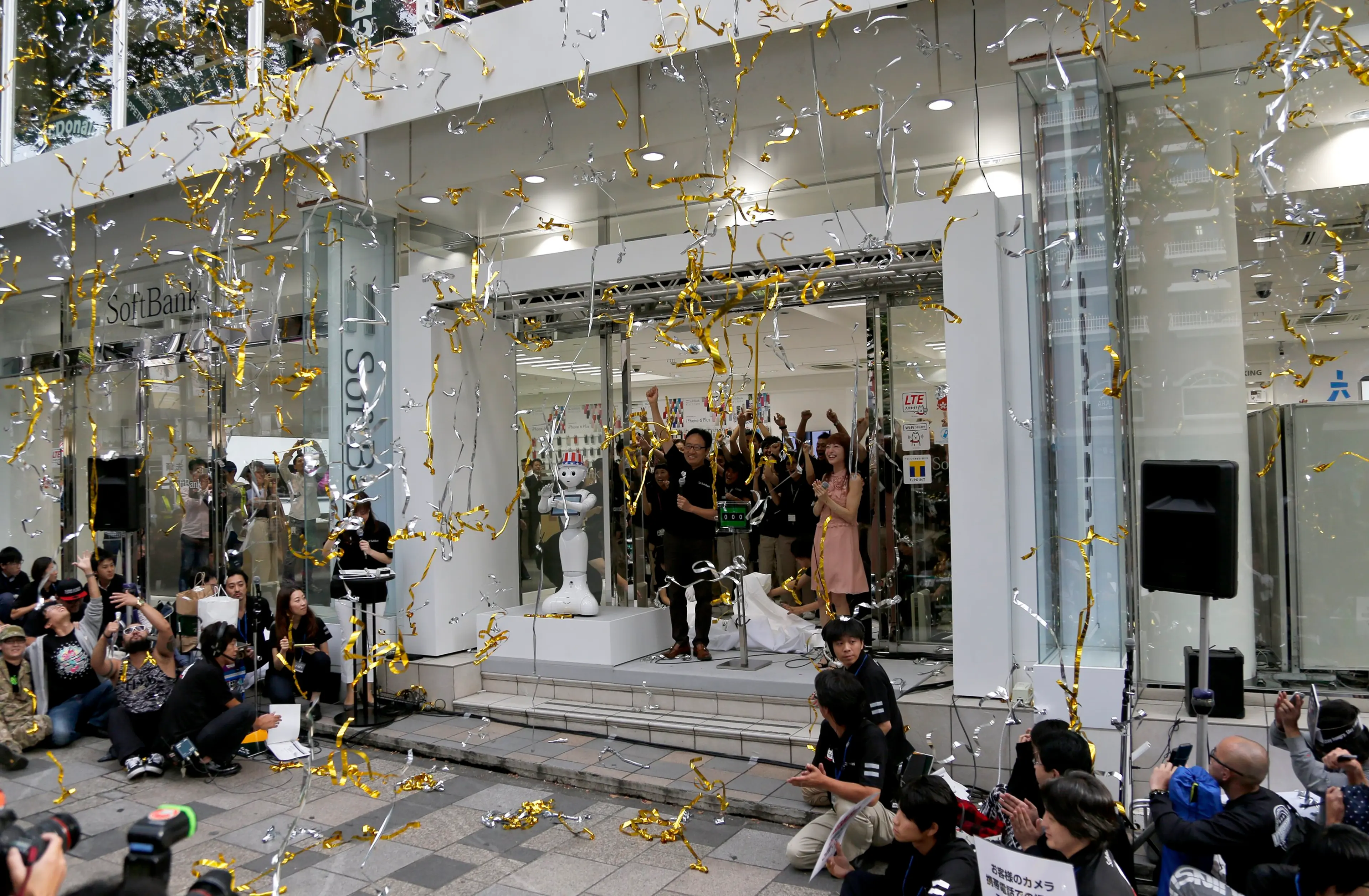 Ken Miyauchi Vice President of Softbank, Japanese mobile phone company and actress Sayaka Kanda, in a pink dress, react during a ceremony to mark the first day of sales of the latest iPhone 6 and 6 Plus at a store in Tokyo on Sept. 19, 2014.