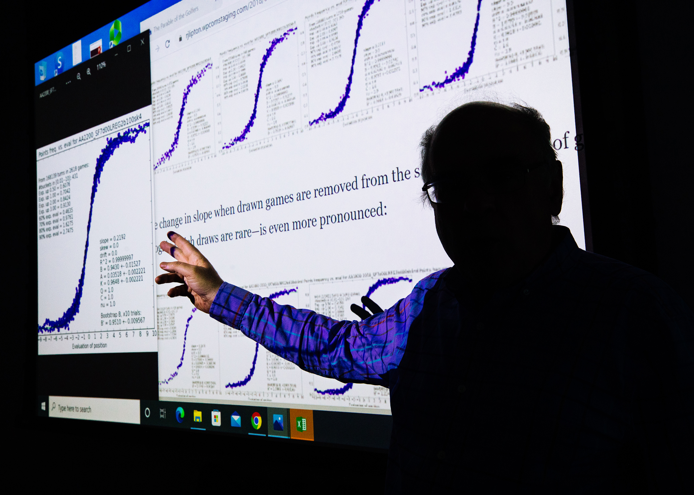 Professor Kenneth Regan inside a classroom at the University at Buffalo School of Engineering and Applied Sciences, where he teaches computer science, on Oct. 29. Behind Regan on the screen is an article he wrote about making the chess cheating test fair across players of all ratings. 