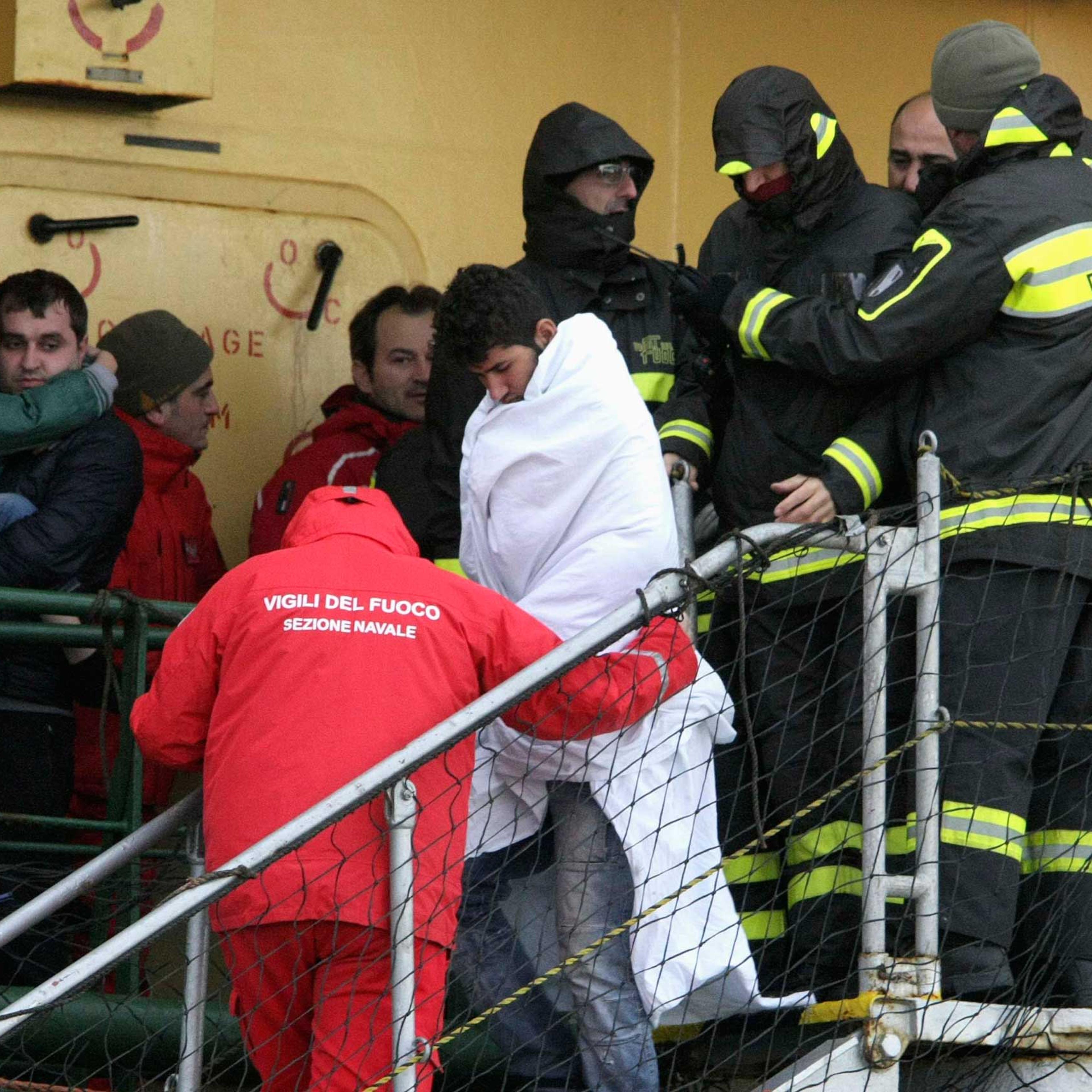 Passenger is helped as he leaves from the " Spirit of Piraeus" cargo container ship as they arrive in Bari harbour, after the car ferry Norman Atlantic caught fire in waters off Greece