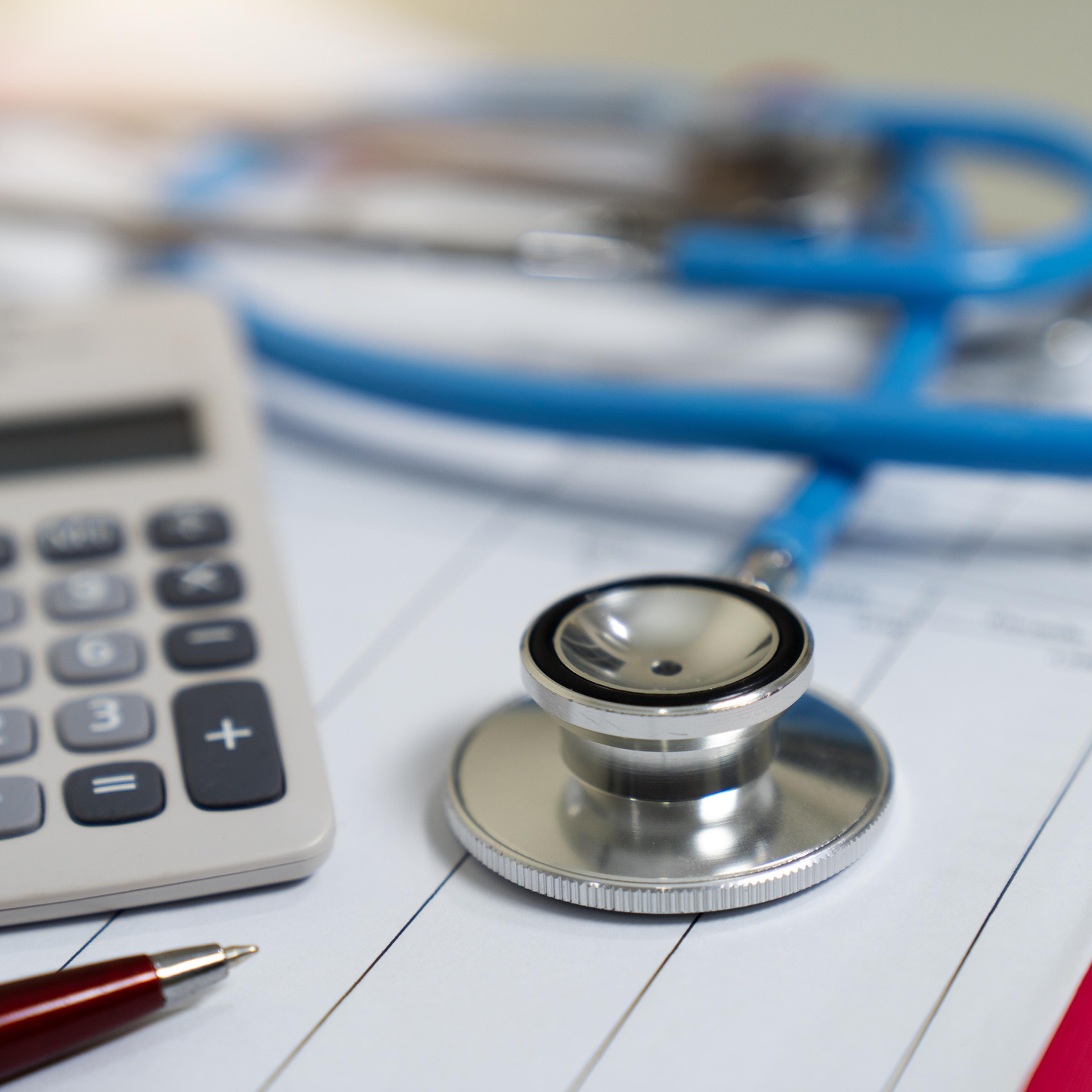 Cost of health care concept, stethoscope and calculator on document