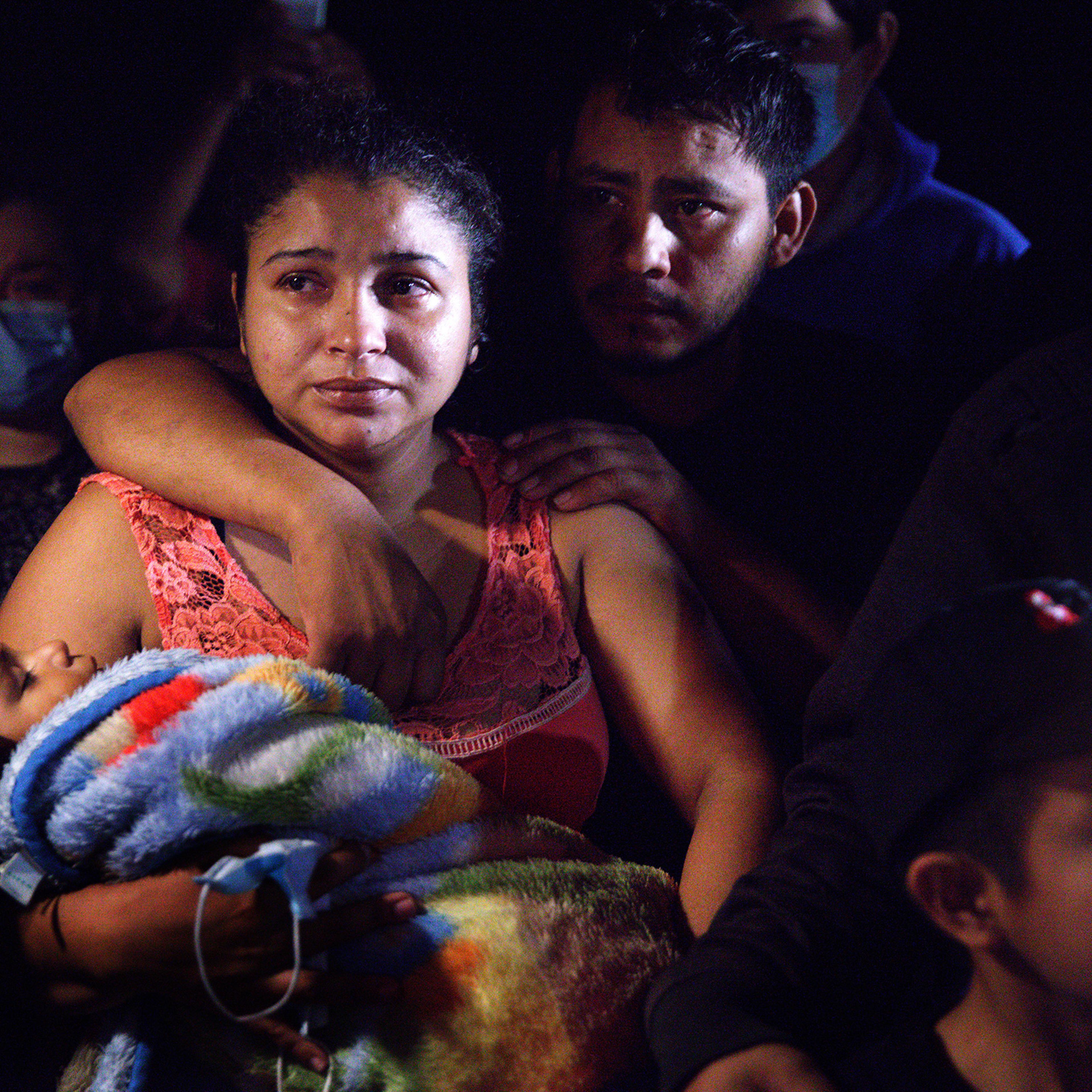 Honduran parents hold their sleeping boy after crossing the Rio Grande from Mexico in Roma, Texas, on April 15, 2021.
