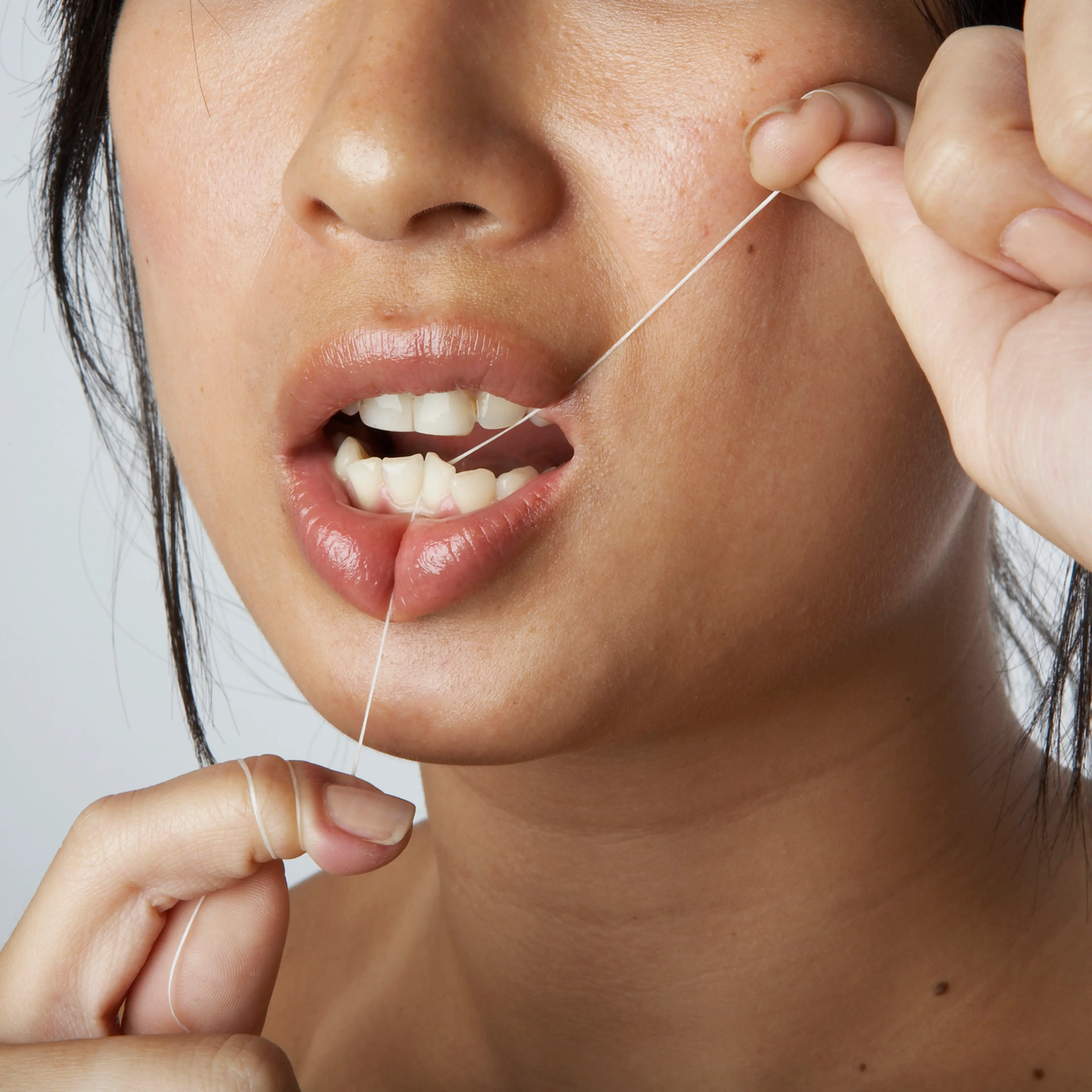 Woman flossing teeth
