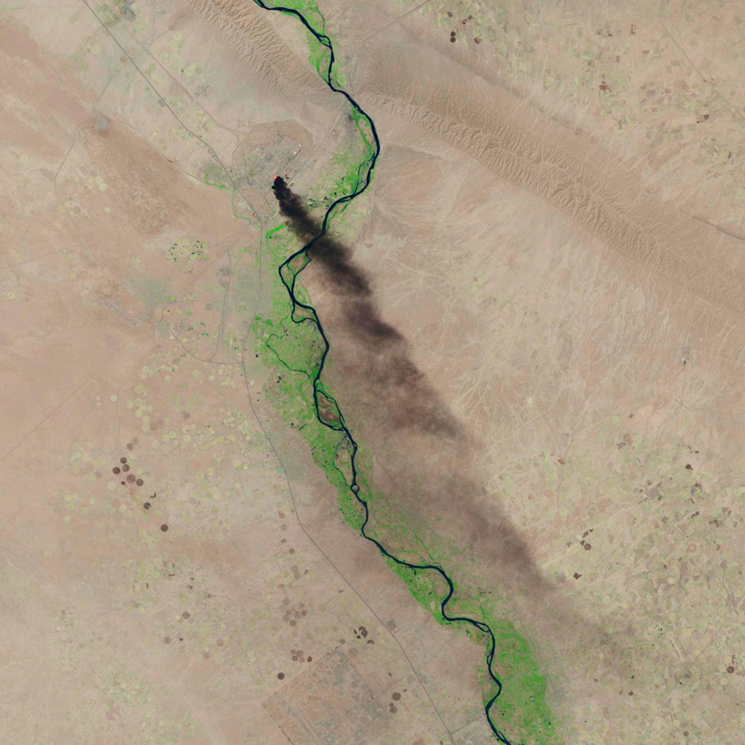 A satellite image shows smoke rising from the Baiji refinery near Tikrit, Iraq, June 18.
