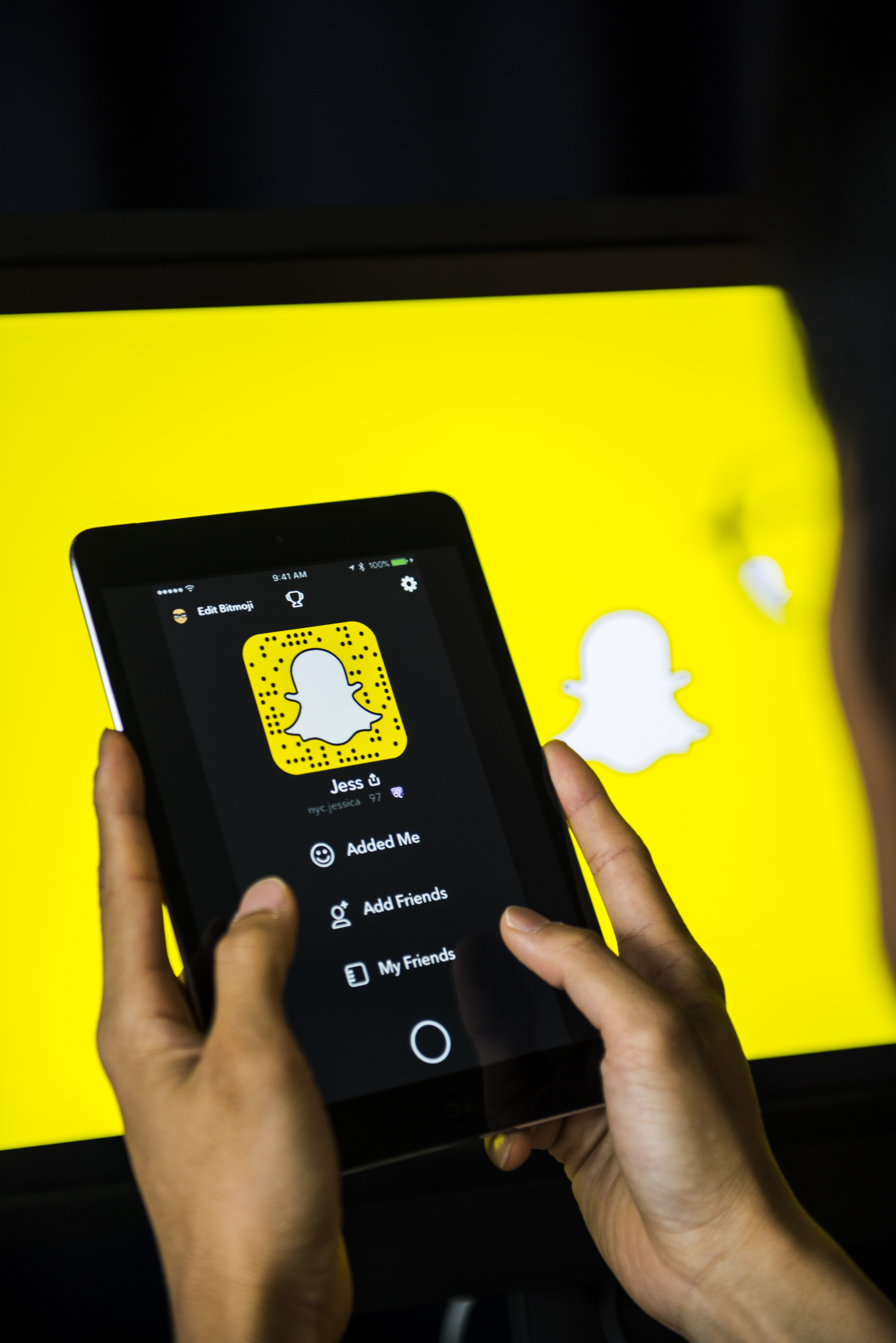 Young man holds a smart device while using SnapChat app