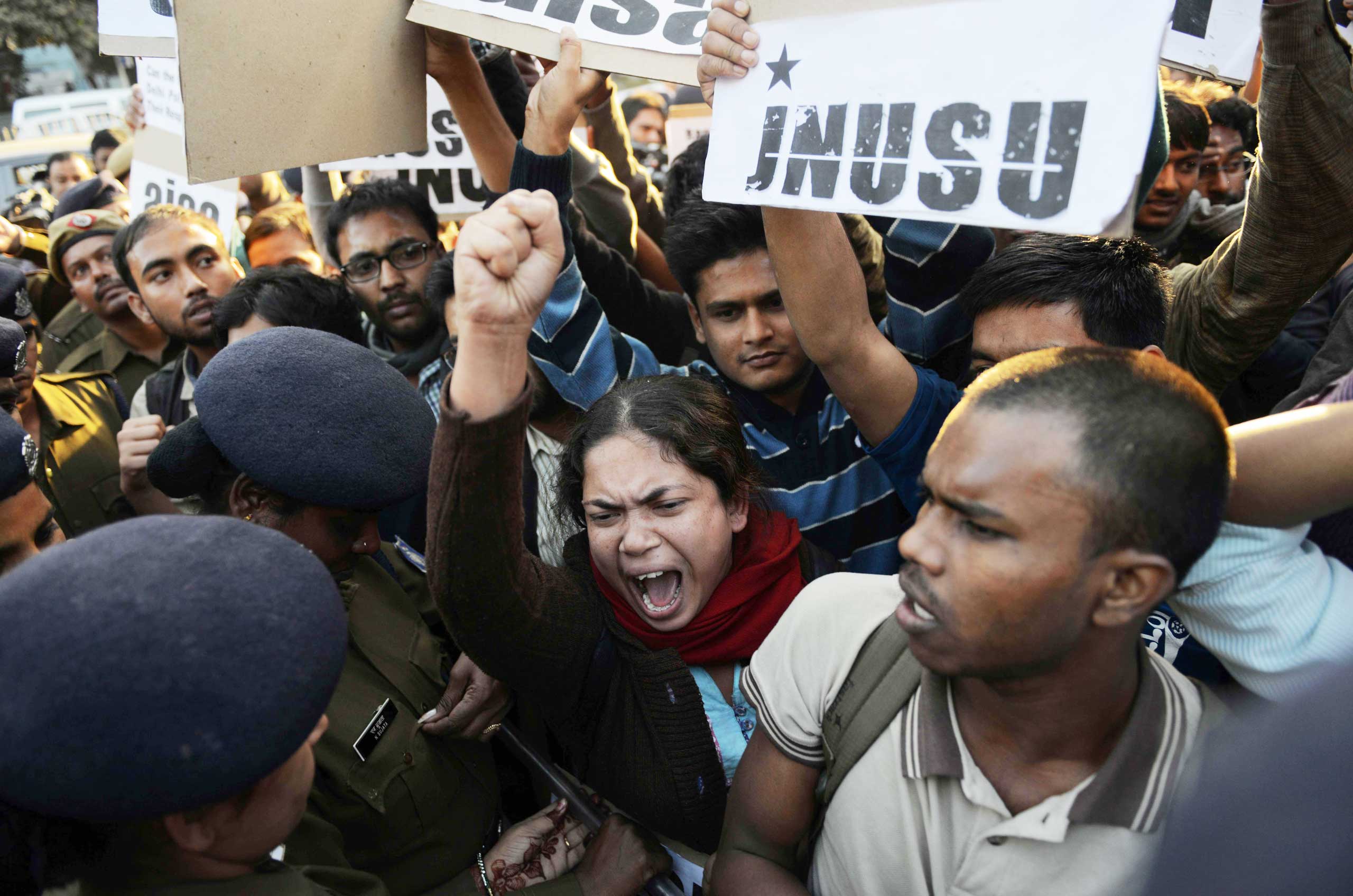 Indian residents hold placards and chant slogans as they take part in a protest against the alleged rape of a passenger by an Uber driver in New Delhi on Dec. 7, 2014.