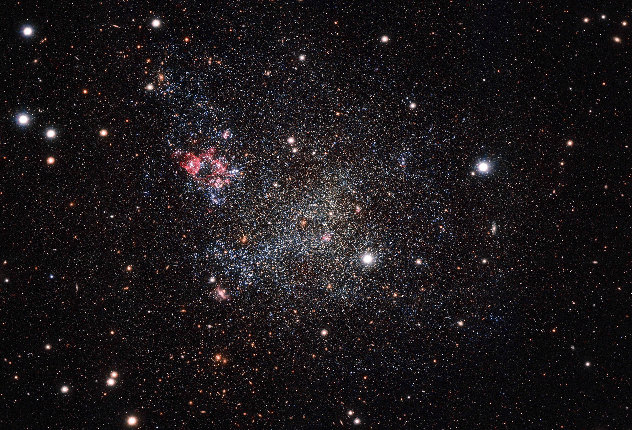 An image of an unusually clean small galaxy called, IC 1613. The galaxy, captured with the OmegaCAM camera on ESO's VLT Survey Telescope in Chile, contains very little cosmic dust, allowing astronomers to explore its contents with great clarity.