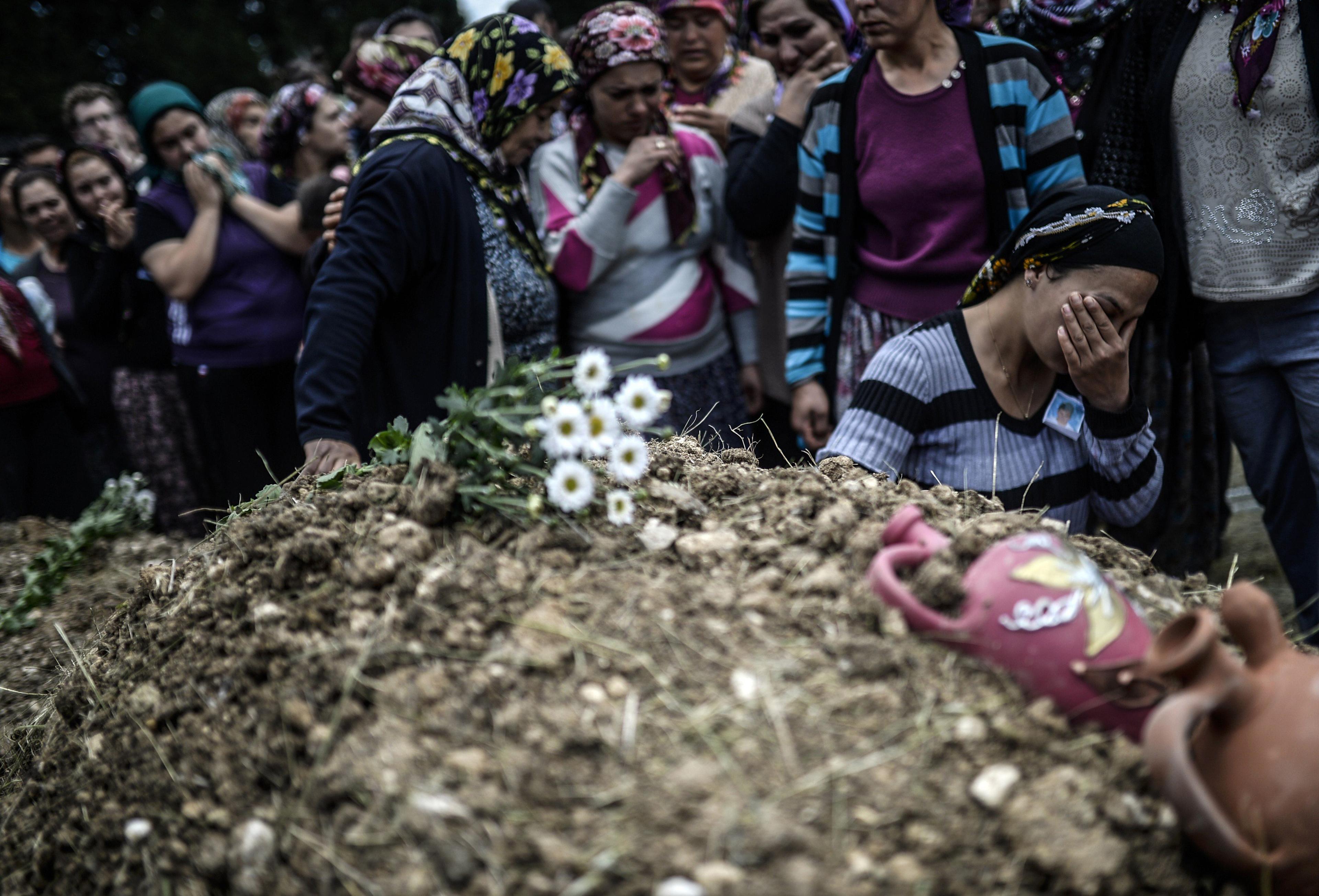 Duygu Colak, reacts as she sits in front of her husband Ugur's grave during a funeral ceremony in the western town of Soma in the Manisa province on May 15, 2014.