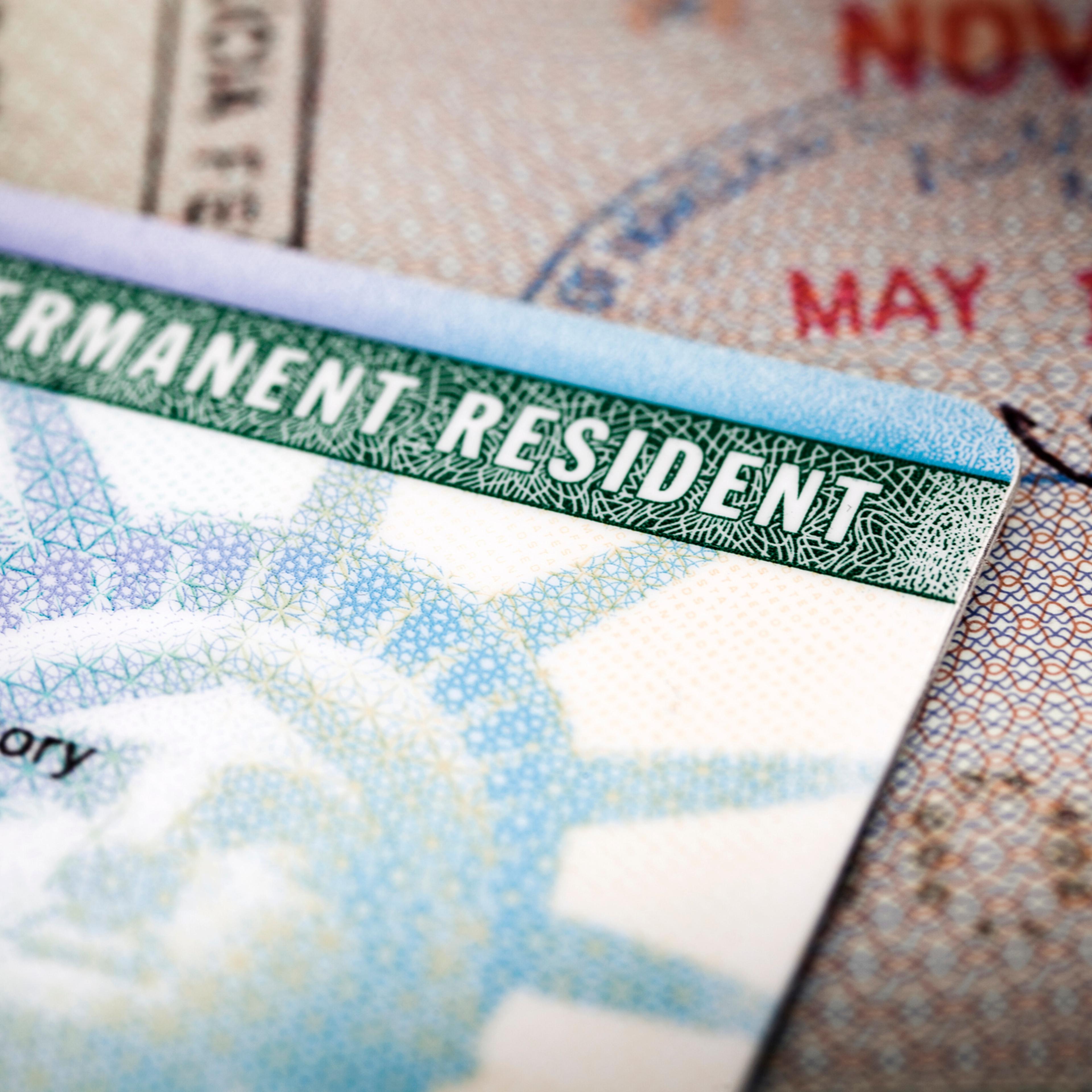 A Green Card lying on an open passport, close-up, full frame