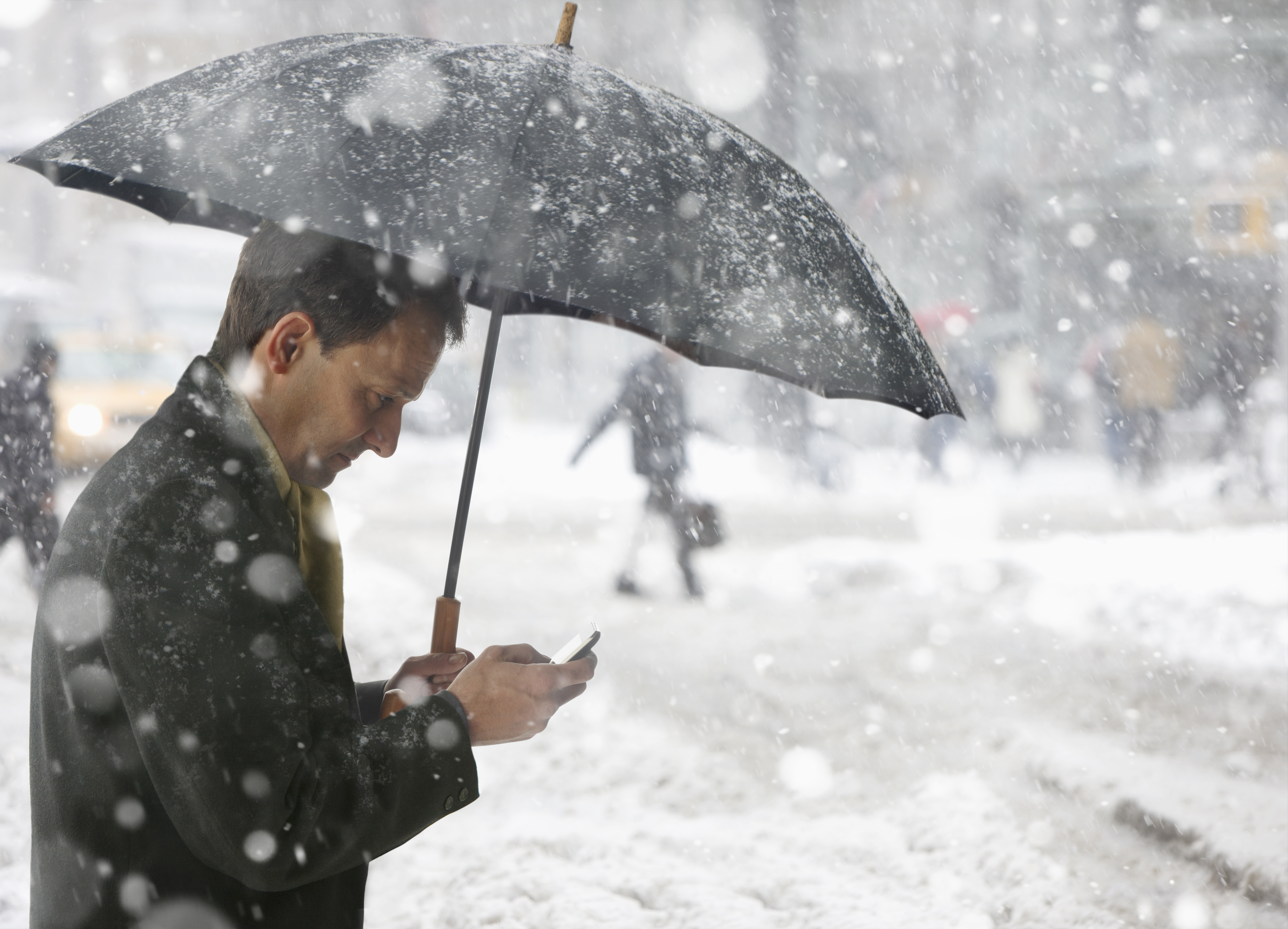 Man checking phone while in the snow