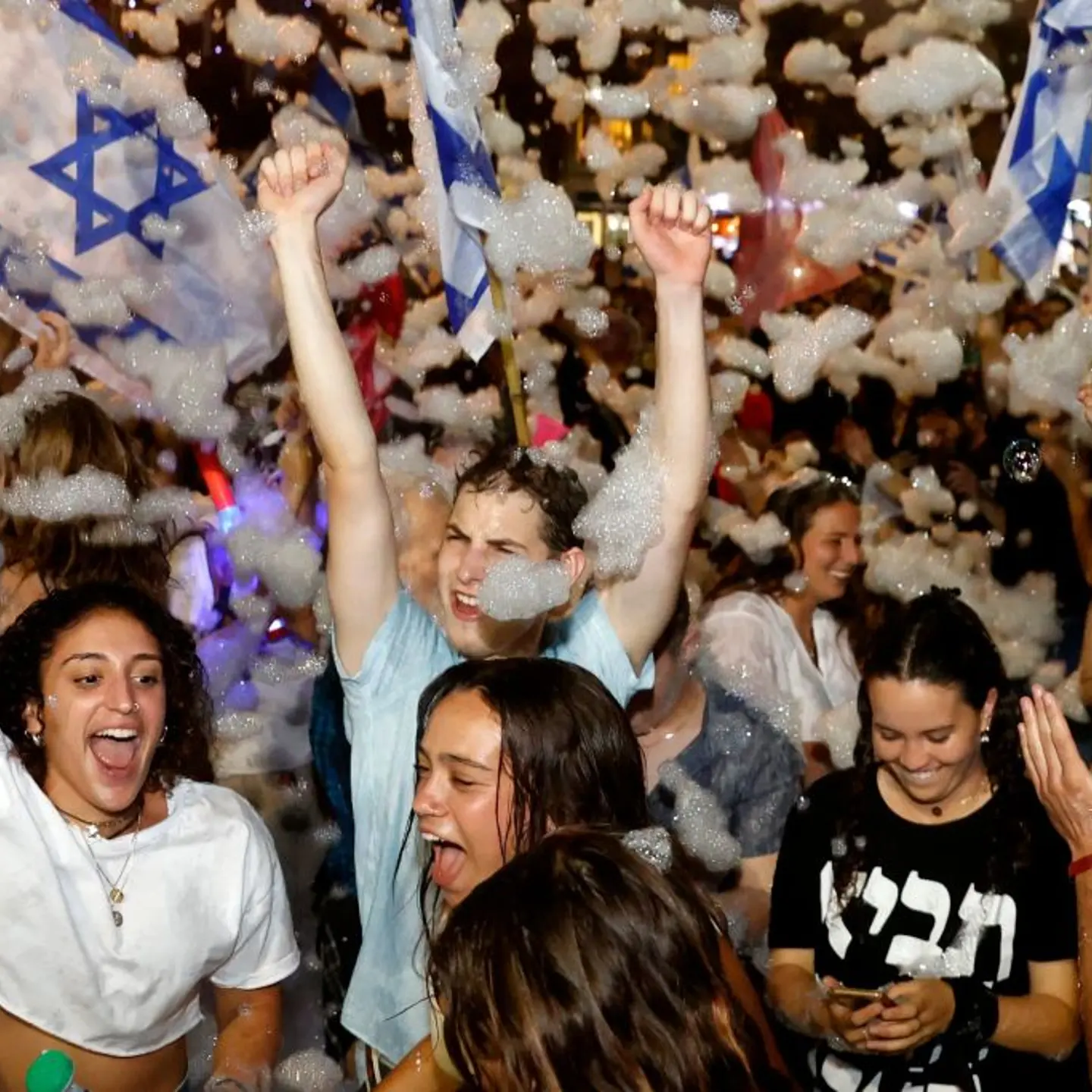 Israeli demonstrators celebrate the passing of a Knesset vote confirming a new coalition government during a rally in Tel Aviv on June 13, 2021.