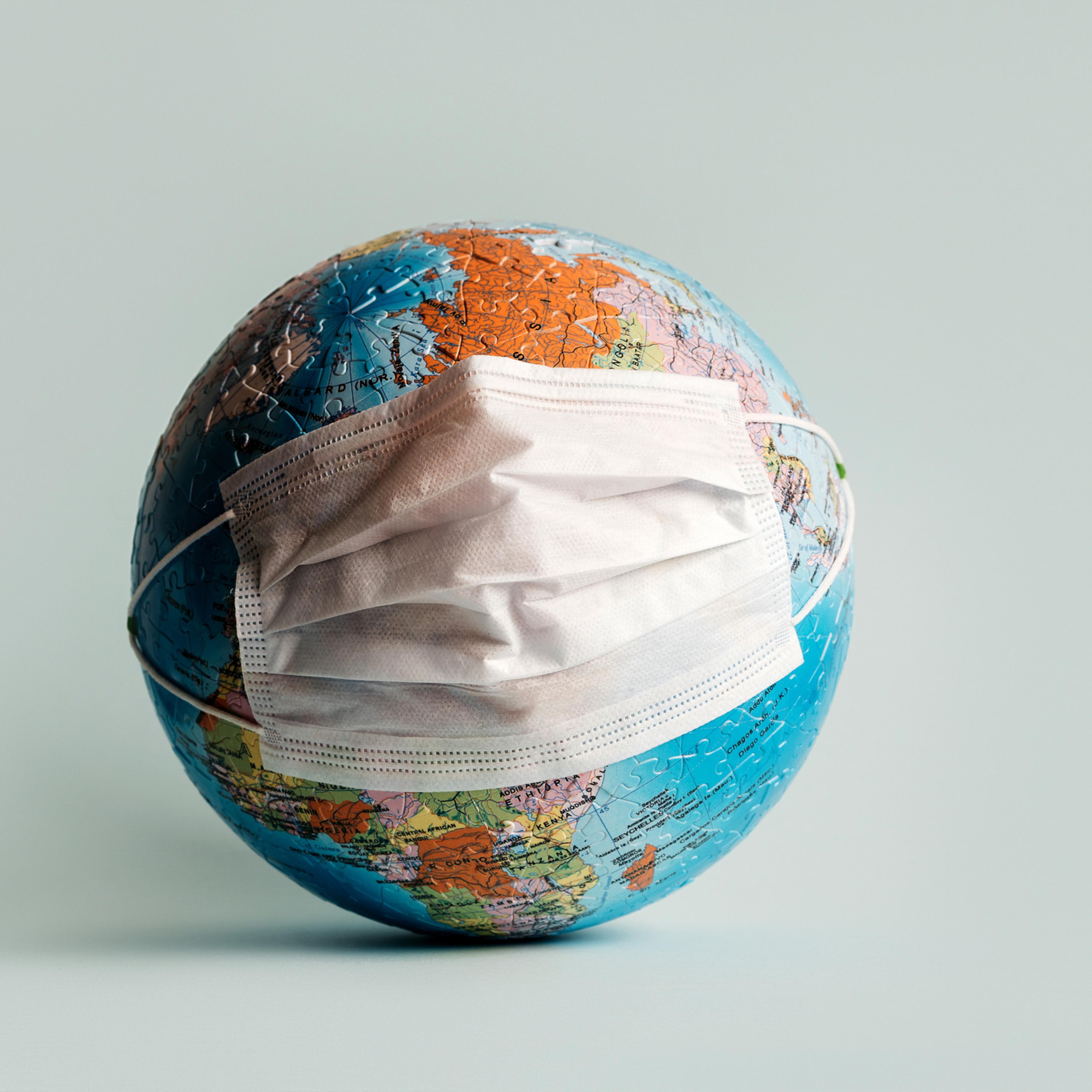 Globe made of jigsaw puzzles with a mask