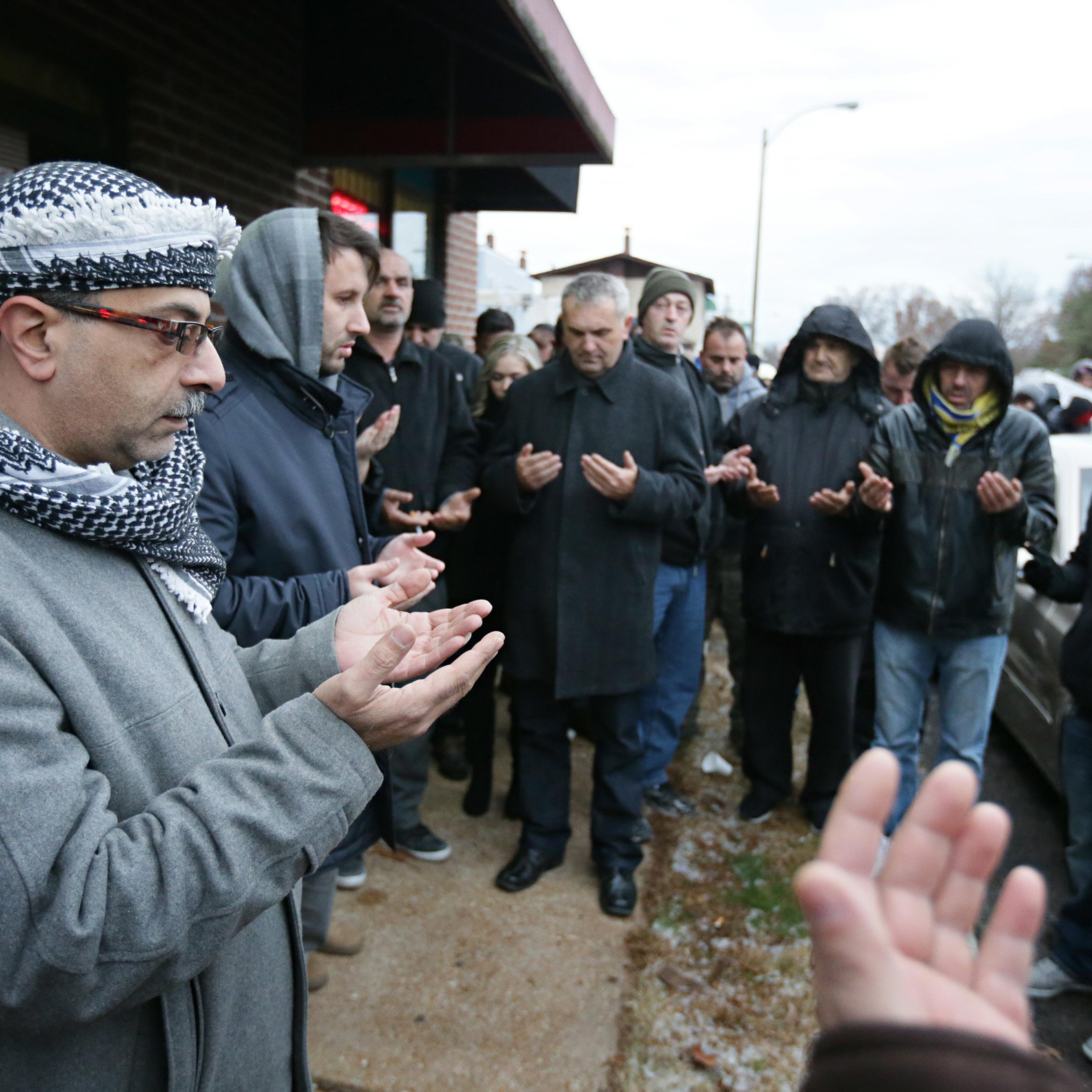 Zuhdi Masri, left, prays for murder victim Zemir Begic with a group of other Bosnians gathered on Holly Hills Avenue in St. Louis on Dec. 1, 2014.