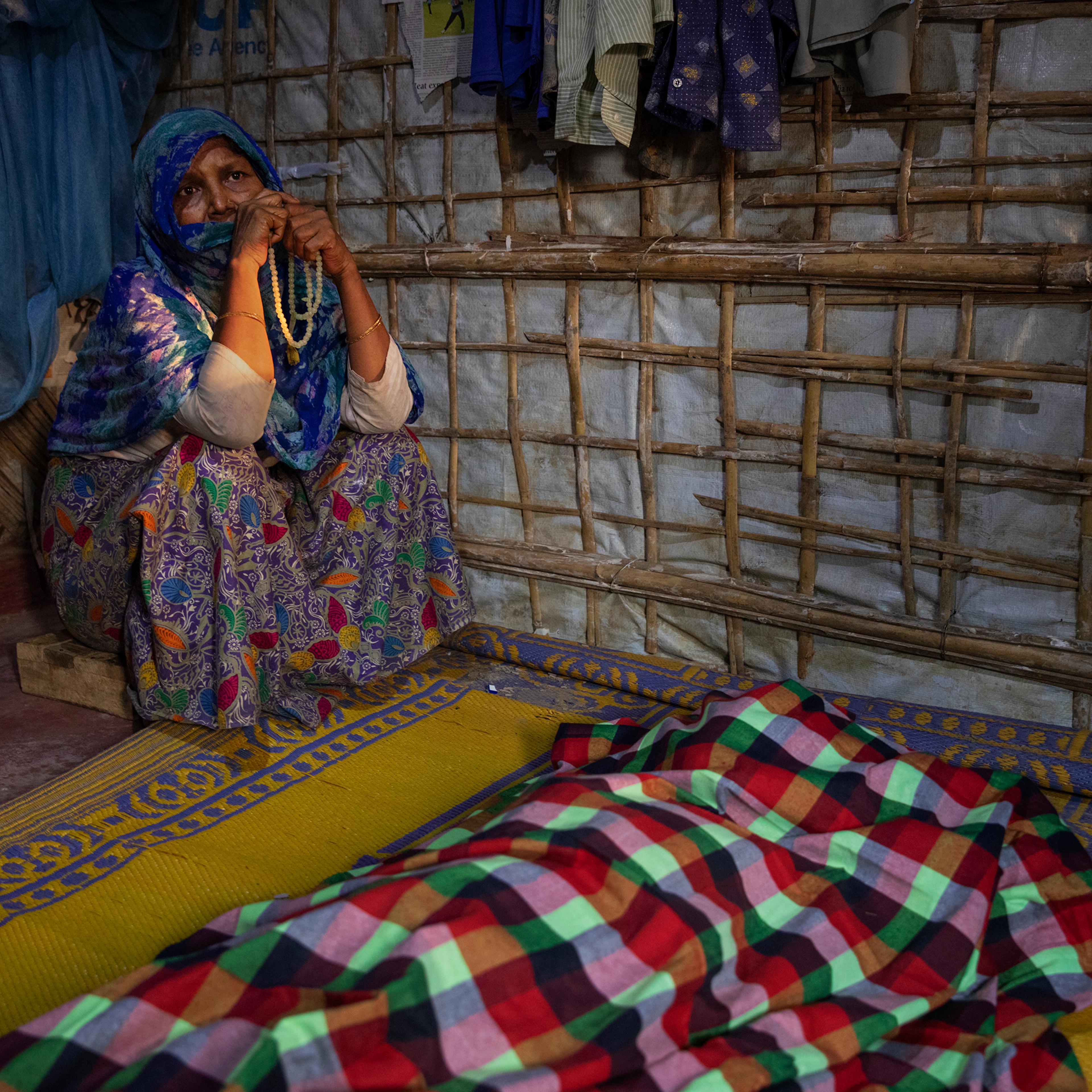 A woman grieves for Fatema Begum, 60, in the hut of the deceased.