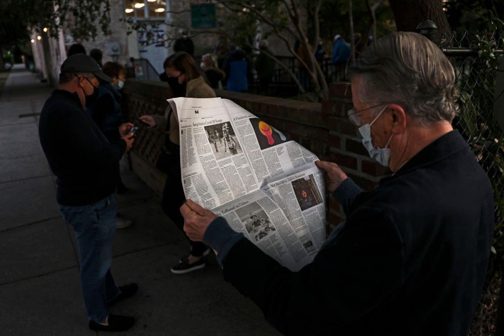 John Winthrop reads a newspaper in line as he waits to vote at the Hazel Parker Playground on Election Day on November 3, 2020 in Charleston, South Carolina.
