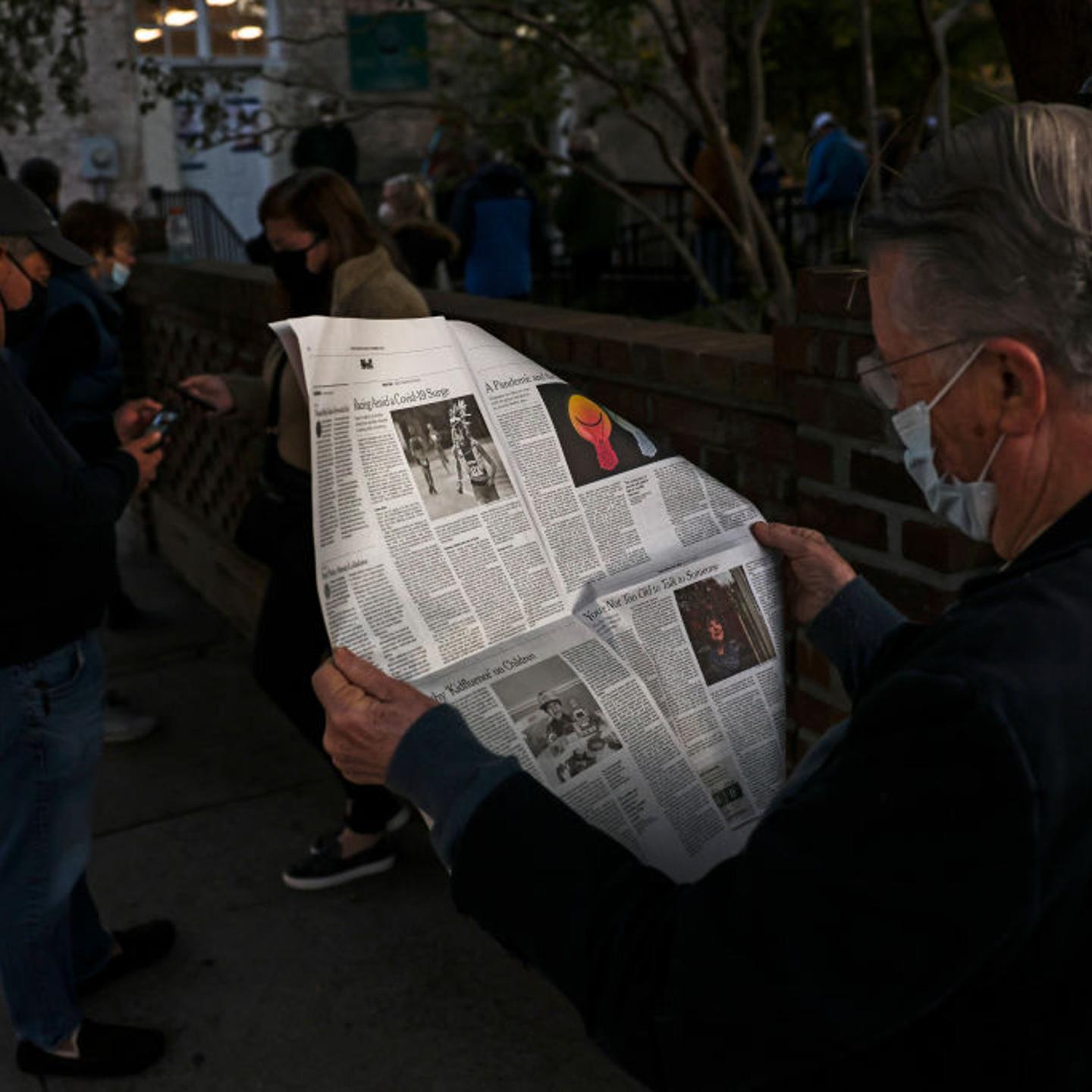 John Winthrop reads a newspaper in line as he waits to vote at the Hazel Parker Playground on Election Day on November 3, 2020 in Charleston, South Carolina.