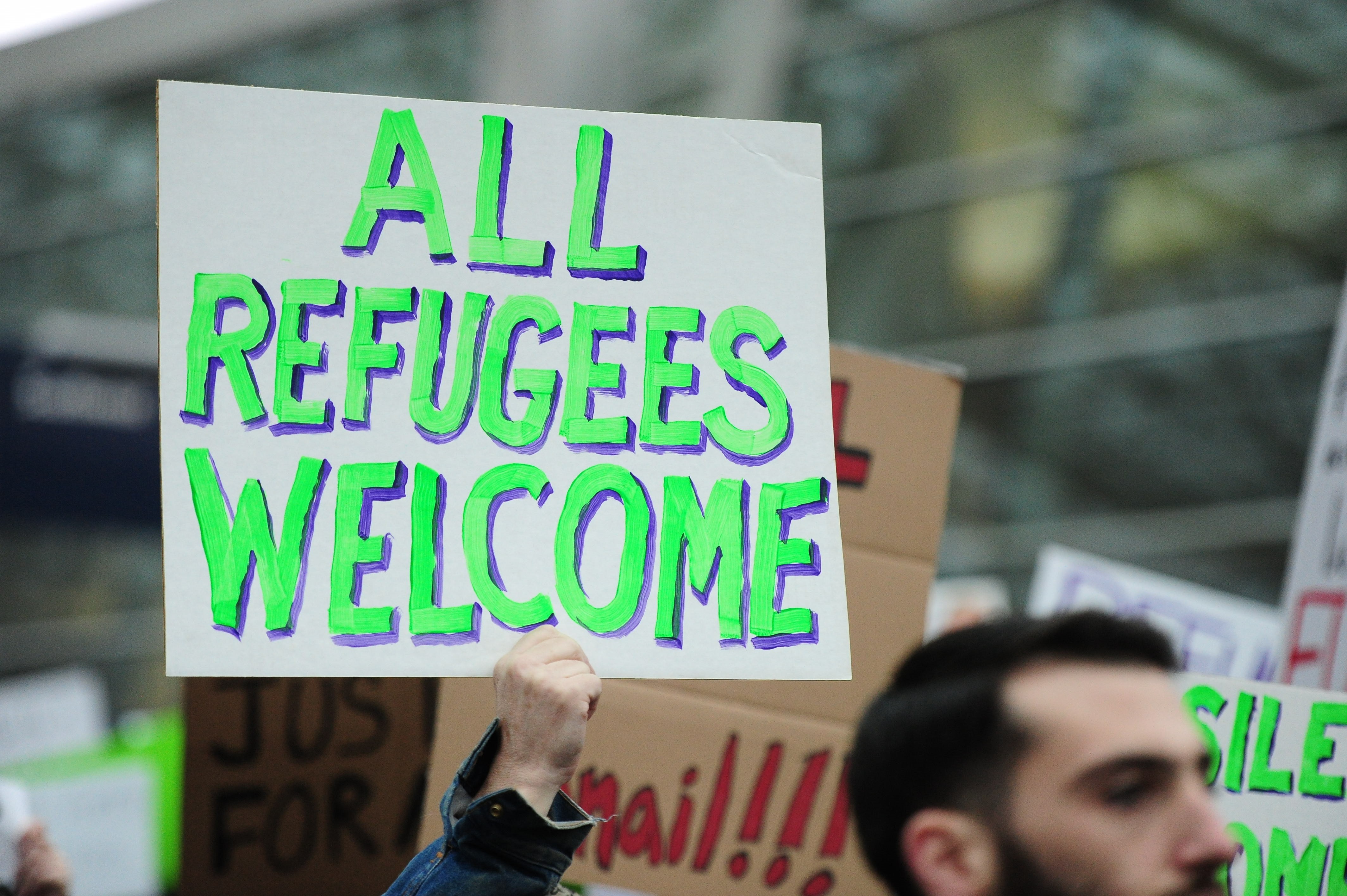 A protester holds a banner during a demonstration against President Trump's immigration ban at Portland International Airport in Portland, United States on January 29, 2017.