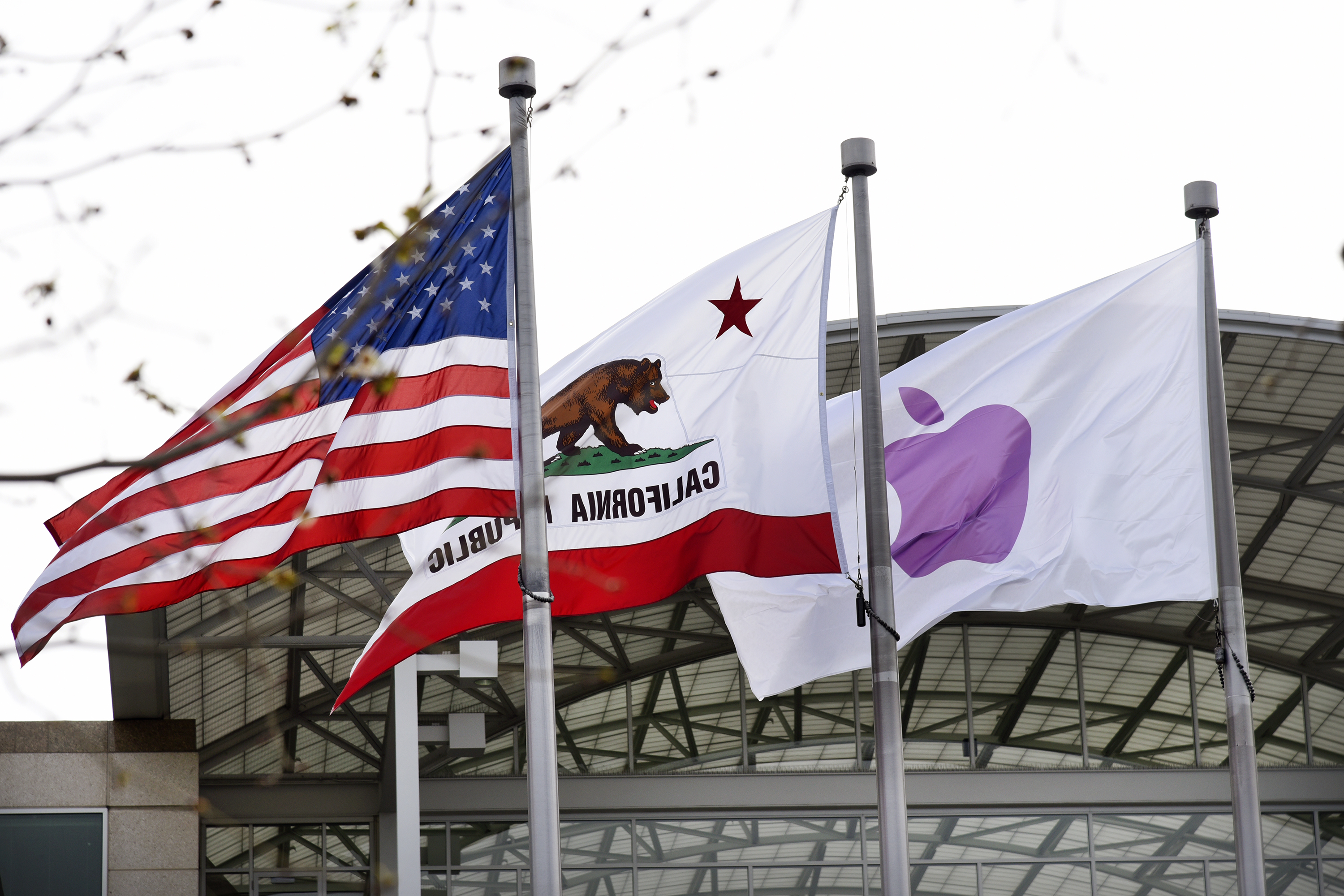 Apple Inc., California Repulbic, and American flags fly outside of company headquarters during an Apple event in Cupertino, California, U.S., on Monday, March 21, 2016.