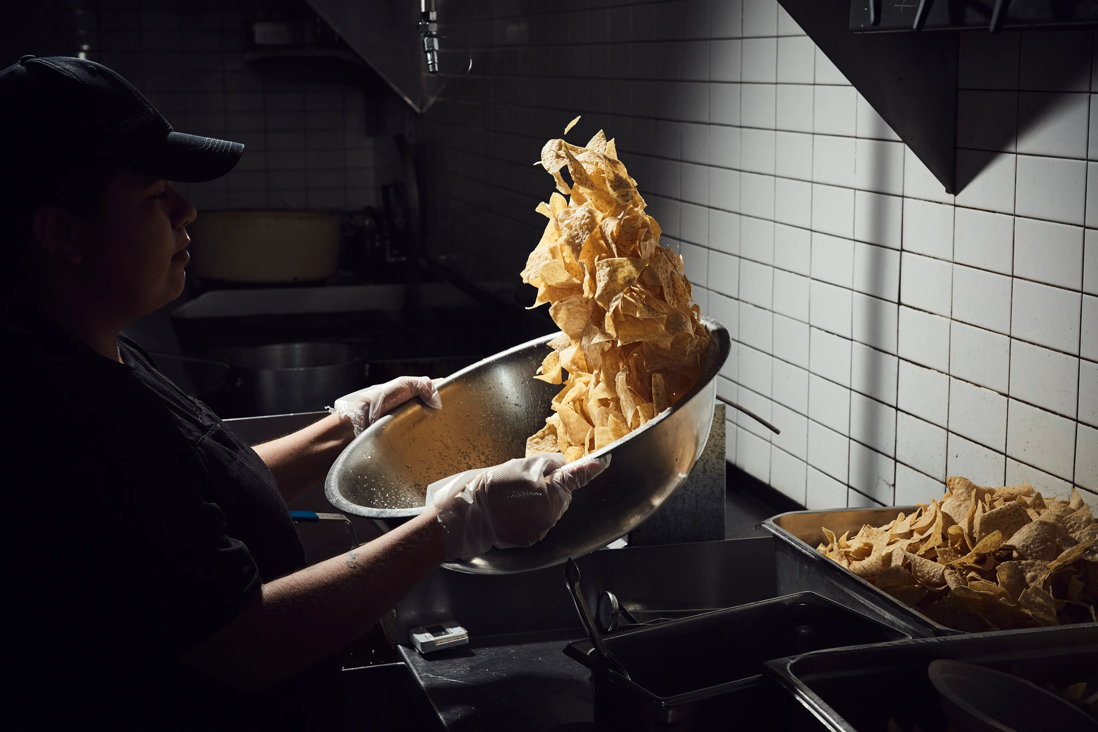 A Chipotle employee seasons chips at a location in Newport Beach, Calif. The company, founded in 1993, now has roughly 70,000 employees and 2,450 locations.