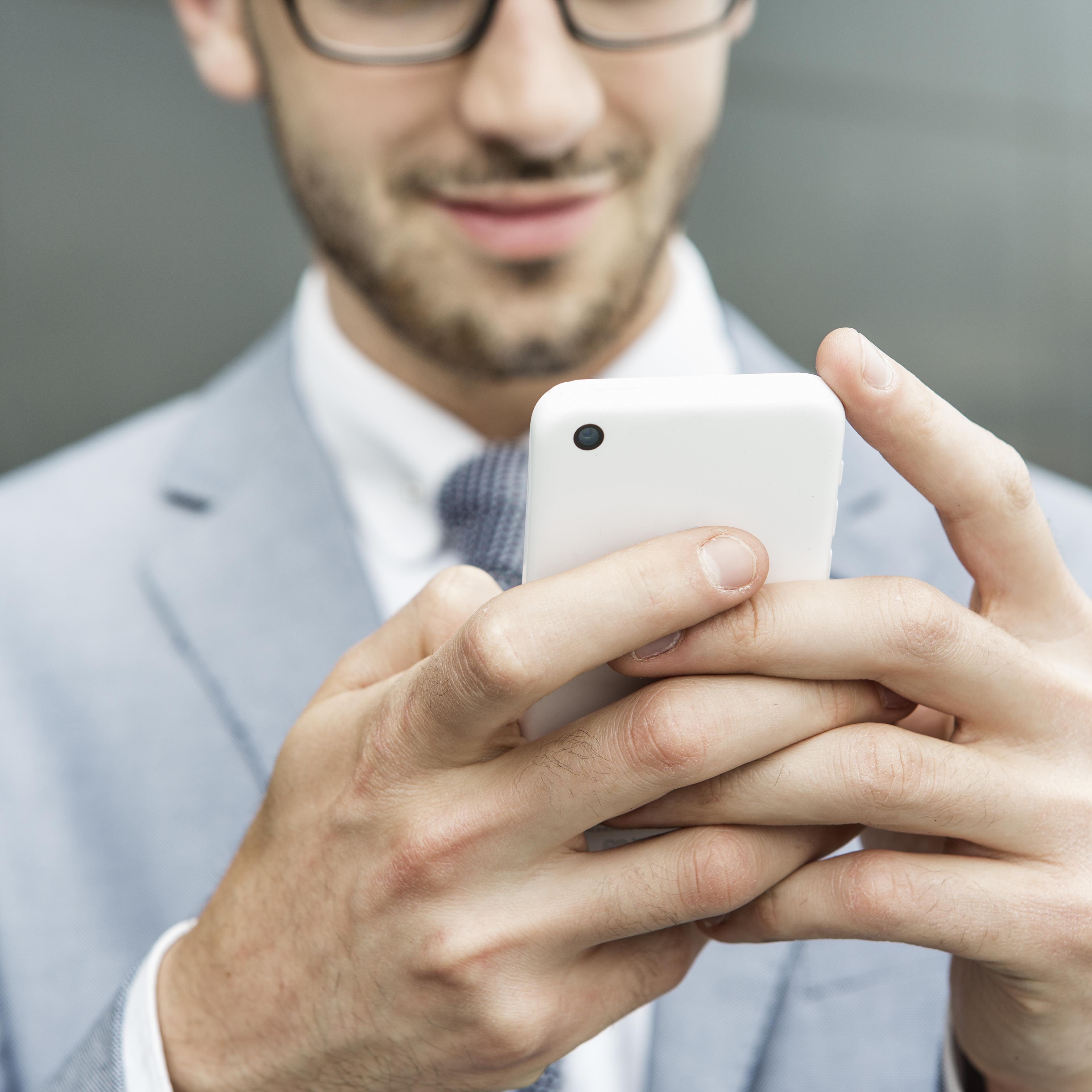Businessman holding mobile phone.