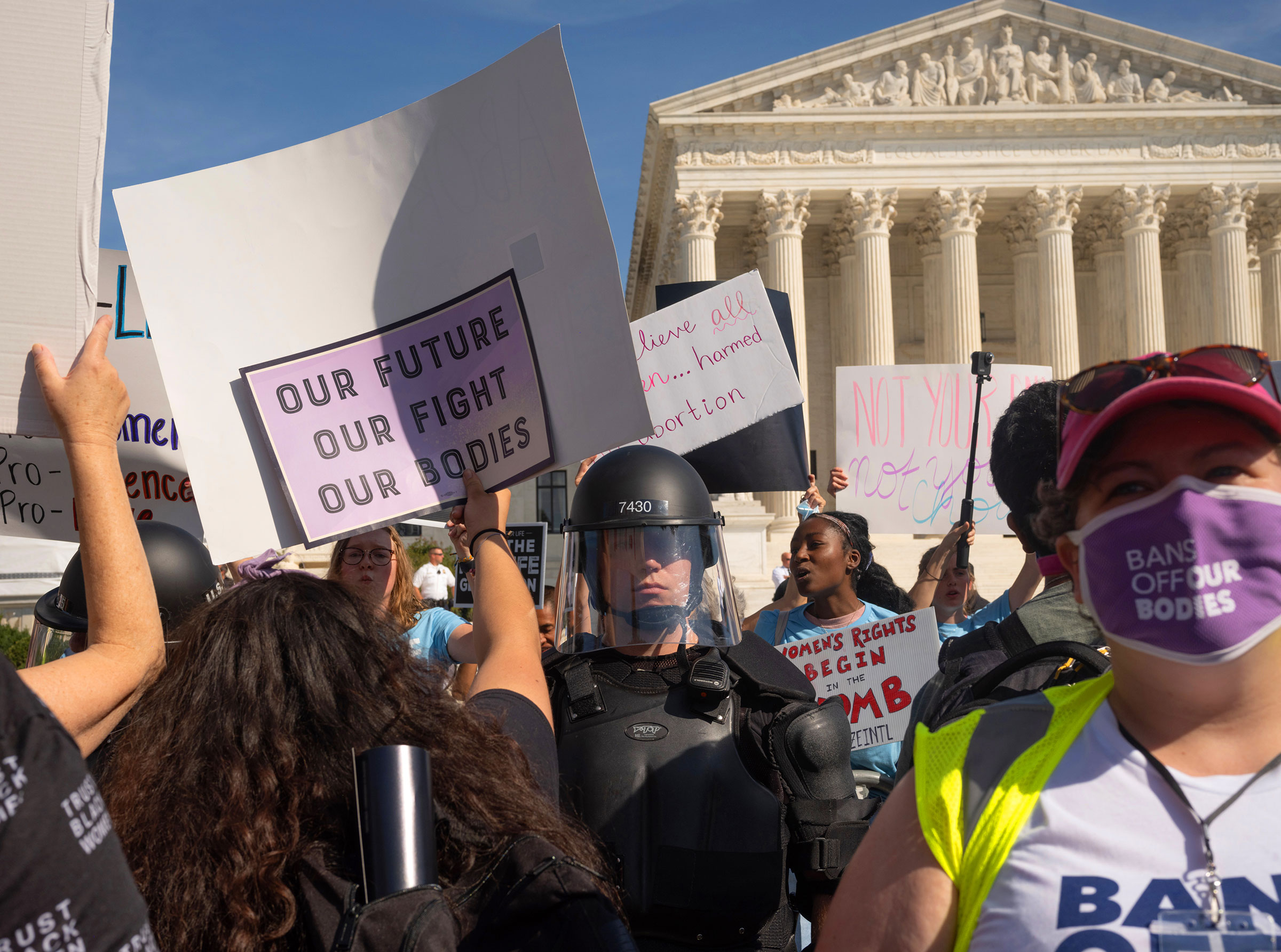 Protesters and counter-protestors meet outside of the Supreme Court at the Women's March and Rally for Abortion Justice in Washington, DC, on October 2, 2021.  Counter-protestors are behind the gates on the side of the Supreme Court, protected by a swat 