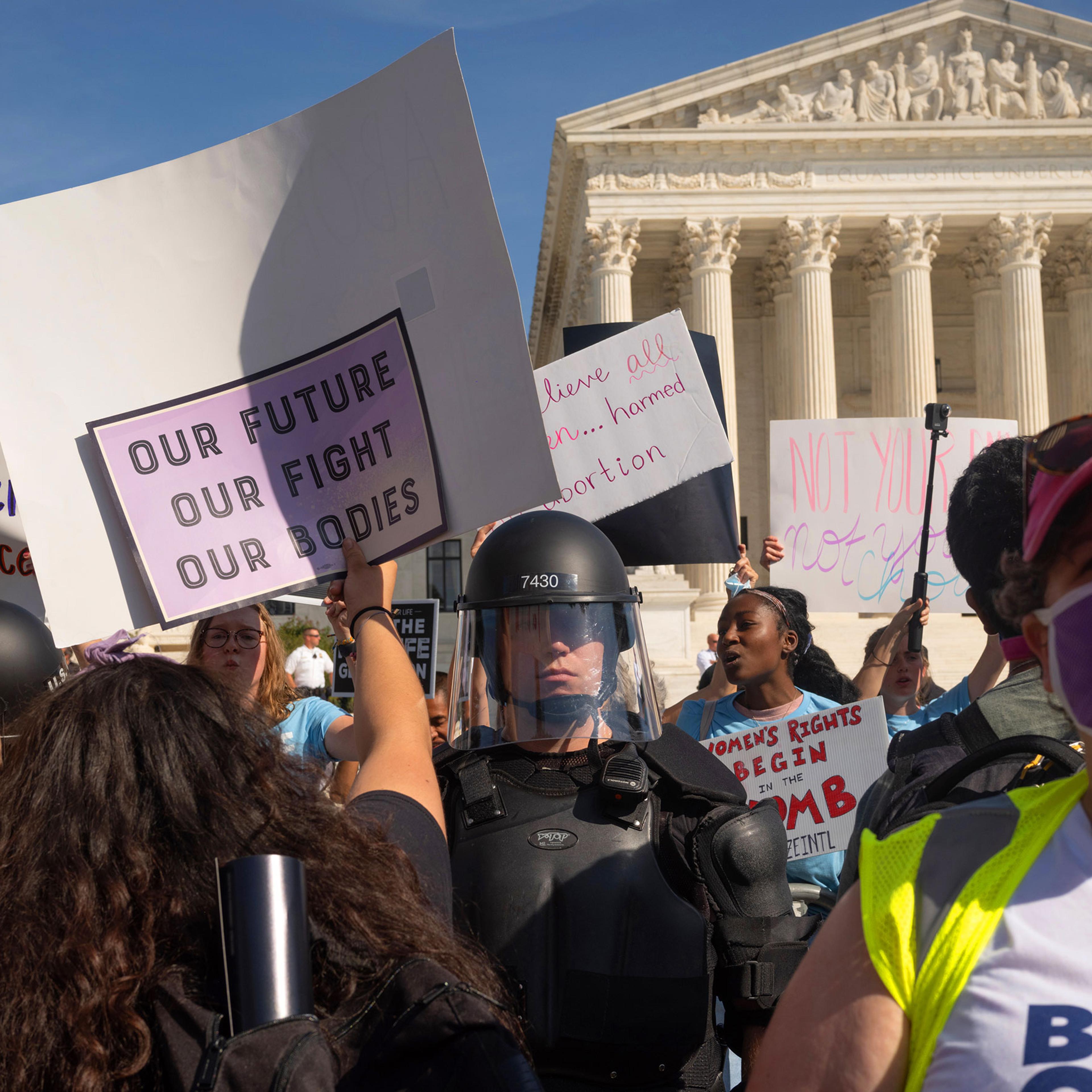 Protesters and counter-protestors meet outside of the Supreme Court at the Women's March and Rally for Abortion Justice in Washington, DC, on October 2, 2021. Counter-protestors are behind the gates on the side of the Supreme Court, protected by a swat
