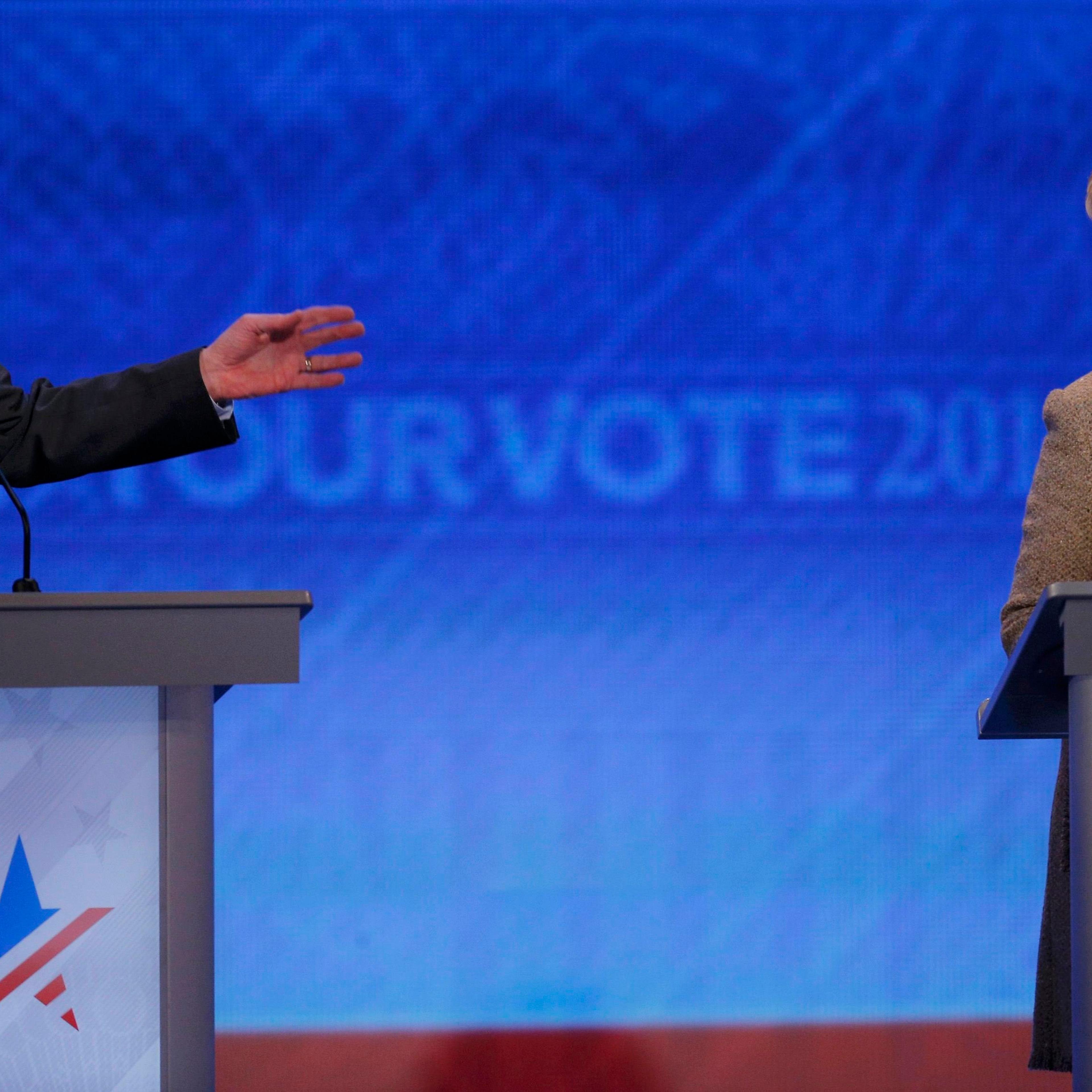 Democratic U.S. presidential candidate Clinton listens as Sanders answers a question at the Democratic presidential candidates debate at St. Anselm College in Manchester