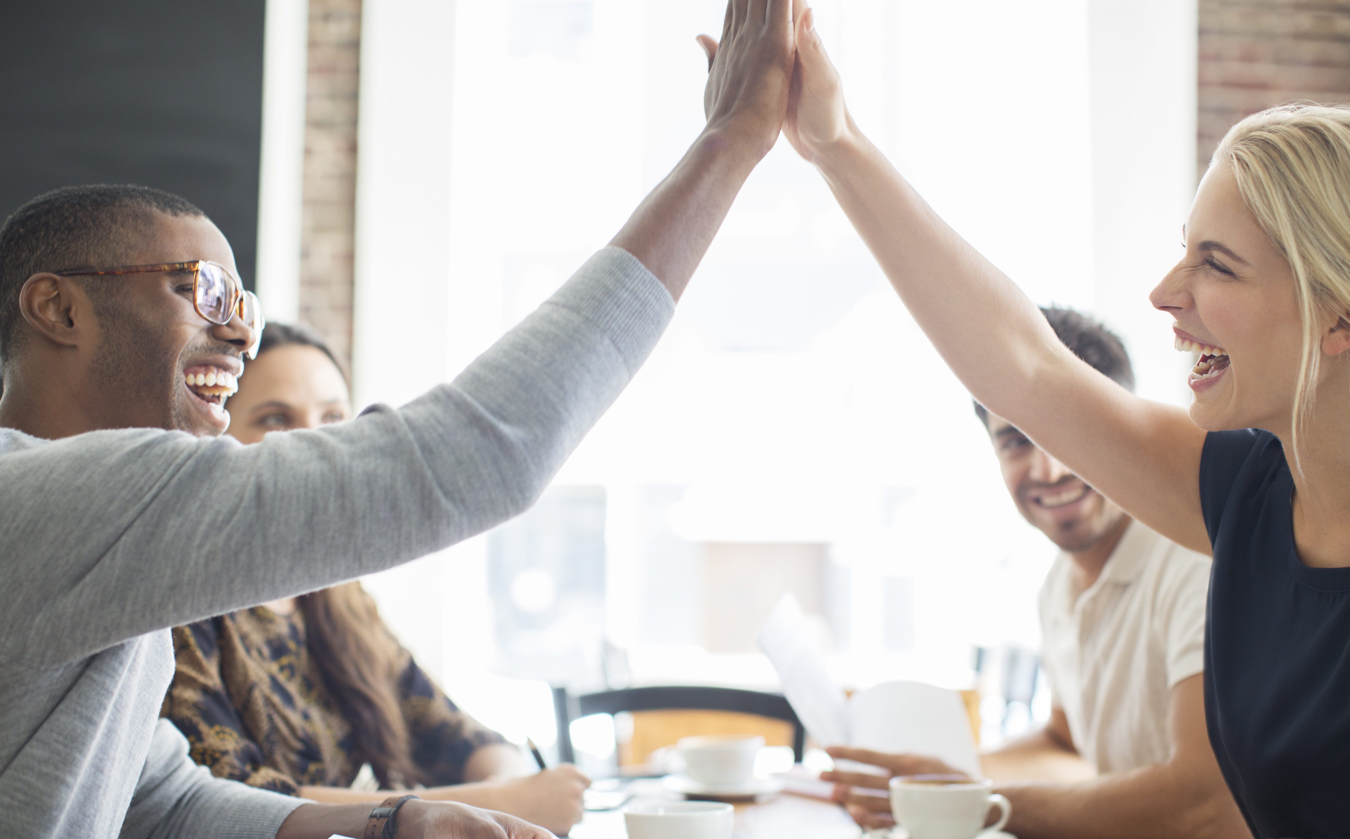 people-cheering-high-five-cafe